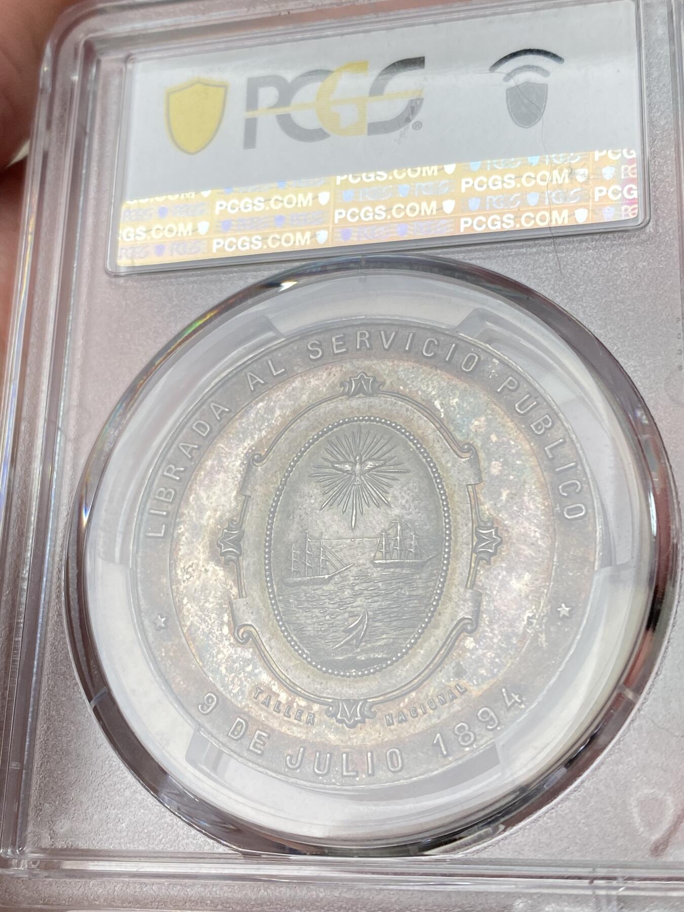 万国钱币拍卖第064期 PCGS MS64 1894年阿根廷布宜诺斯艾利斯五月大道向公众开放纪念大银章 罕见五彩南美银章37MM厚重精铸美丽 其东端玫瑰宫和总统府与西边终点新国会大厦连接起来 道路两旁是法国古典主义建筑和新艺术派建筑 PC唯一冠军分