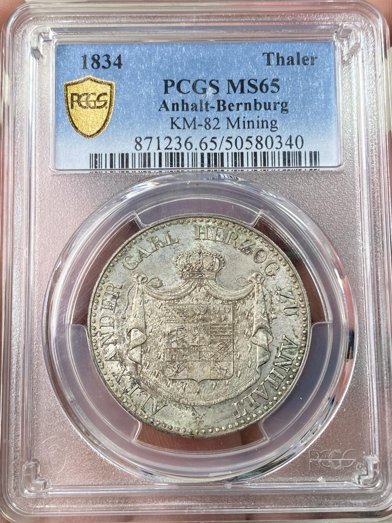 万国钱币拍卖第064期 PCGS MS65 1834年德国安哈尔特-贝恩堡矿业祈祷纹章流通1泰勒 唯一一款贝恩堡窗帘形态1泰勒 小熊爬墙的前身 仅单年发行15000枚且流通充分 即便通货也是难得一见 能达到BU品质可谓凤毛麟角 全深打丝绸转光地板 极美香槟色调淡彩环绕 PCGS唯一冠军分唯一MS 亚军就是XF40 其难度可见一斑 入库收藏重器级别