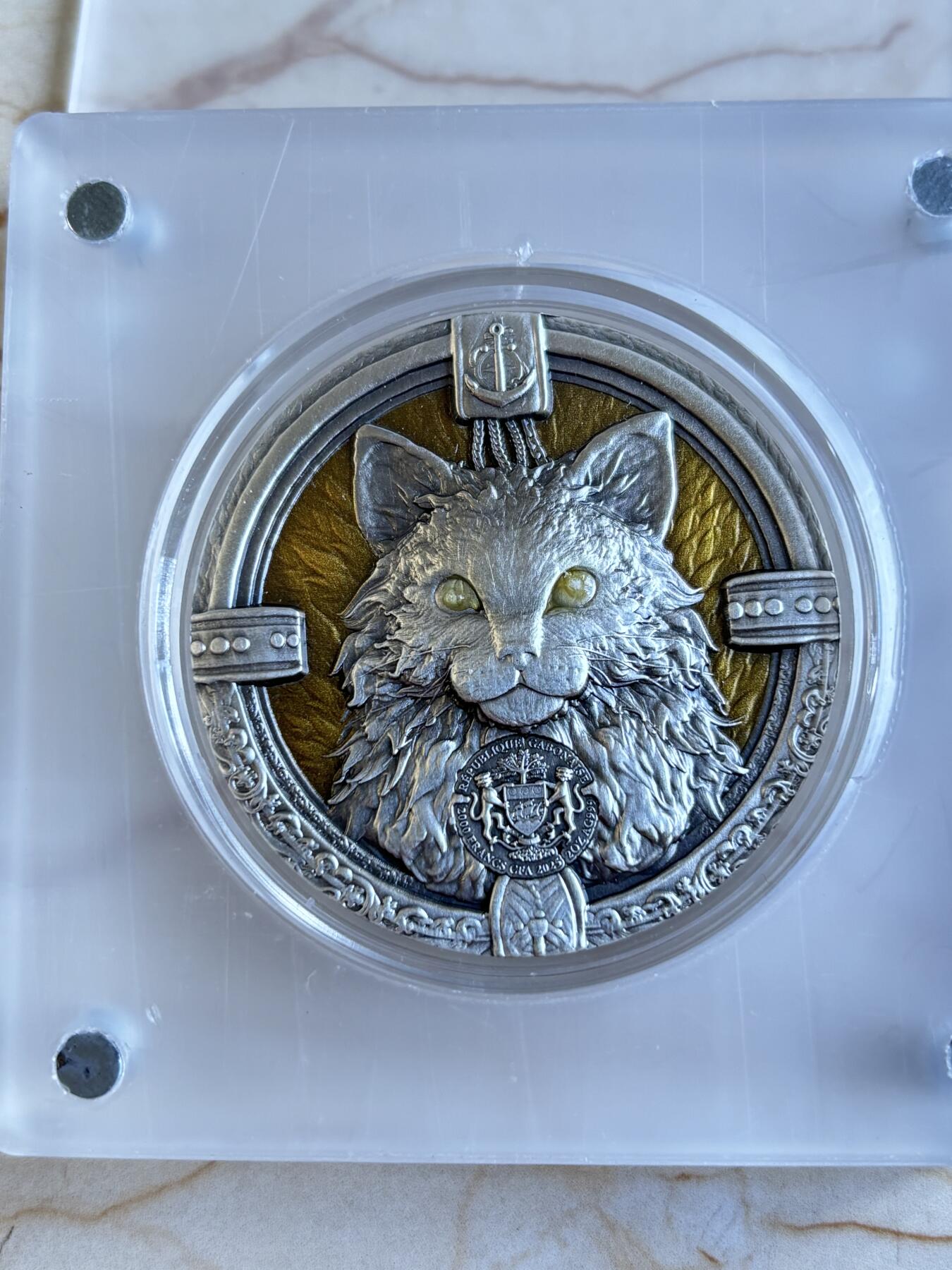 第195期拍卖 加蓬2025年海上舰猫2盎司仿古彩色夜光高浮雕银币，999银，编号108，总发行量999枚，原盒证书，发售价1788元