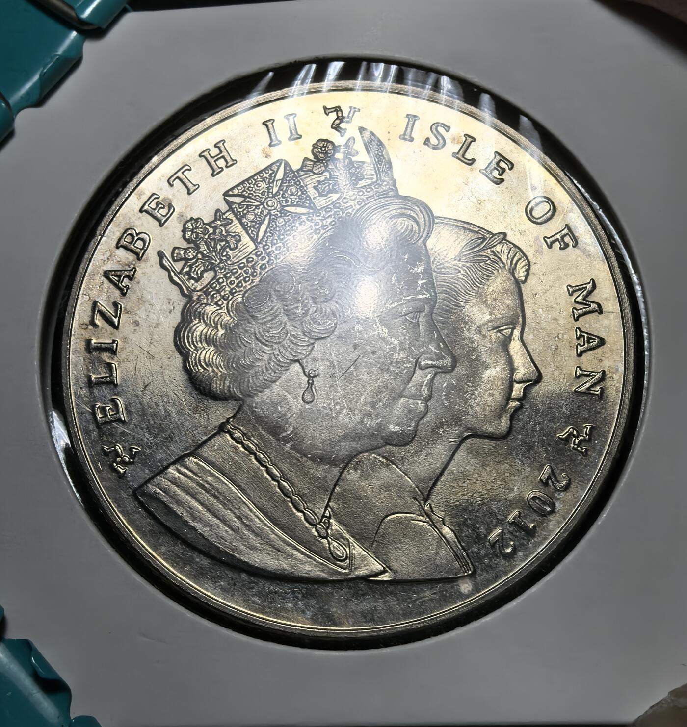 外国优质银币克朗币纪念章，每周六晚九点倒数截拍，满百包邮可寄存，持续收拍 马恩岛2012年伊丽莎白二世登基钻禧 1 克朗纪念币，正面为女王今昔双头像，背面以加冕坐像与王权象征，纪念其在位 60 周年，见证马恩岛与英王室的历史联结。