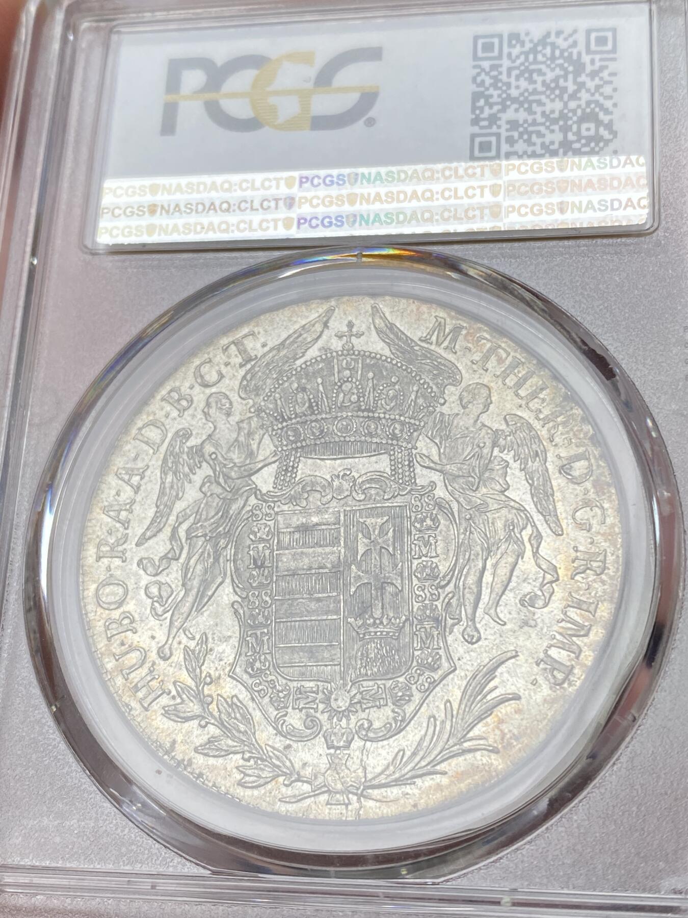 万国钱币拍卖第064期 PCGS MS63 1780年匈牙利神圣罗马帝国皇帝约瑟夫二世圣母抱婴泰勒 克雷姆琴察造币厂铸 高品罕见的神罗匈牙利洗礼 PC亚军分更高仅一枚 圣光环绕着圣母与圣子 背面两位大天使献上祝福 超级深铸银光充沛无减重痕罕见典藏级
