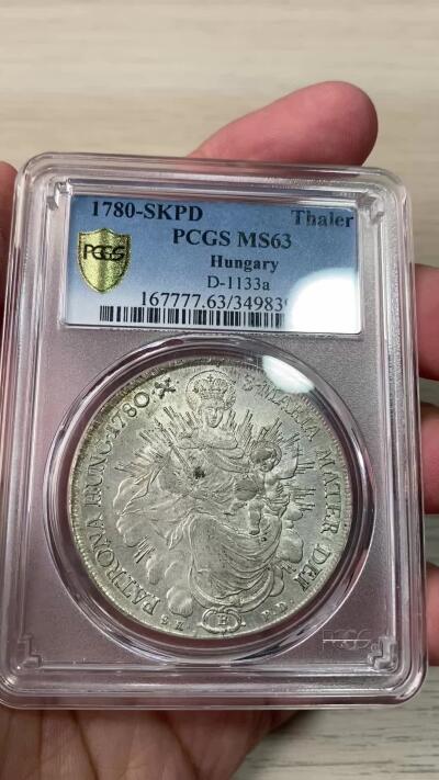 万国钱币拍卖第064期 PCGS MS63 1780年匈牙利神圣罗马帝国皇帝约瑟夫二世圣母抱婴泰勒 克雷姆琴察造币厂铸 高品罕见的神罗匈牙利洗礼 PC亚军分更高仅一枚 圣光环绕着圣母与圣子 背面两位大天使献上祝福 超级深铸银光充沛无减重痕罕见典藏级
