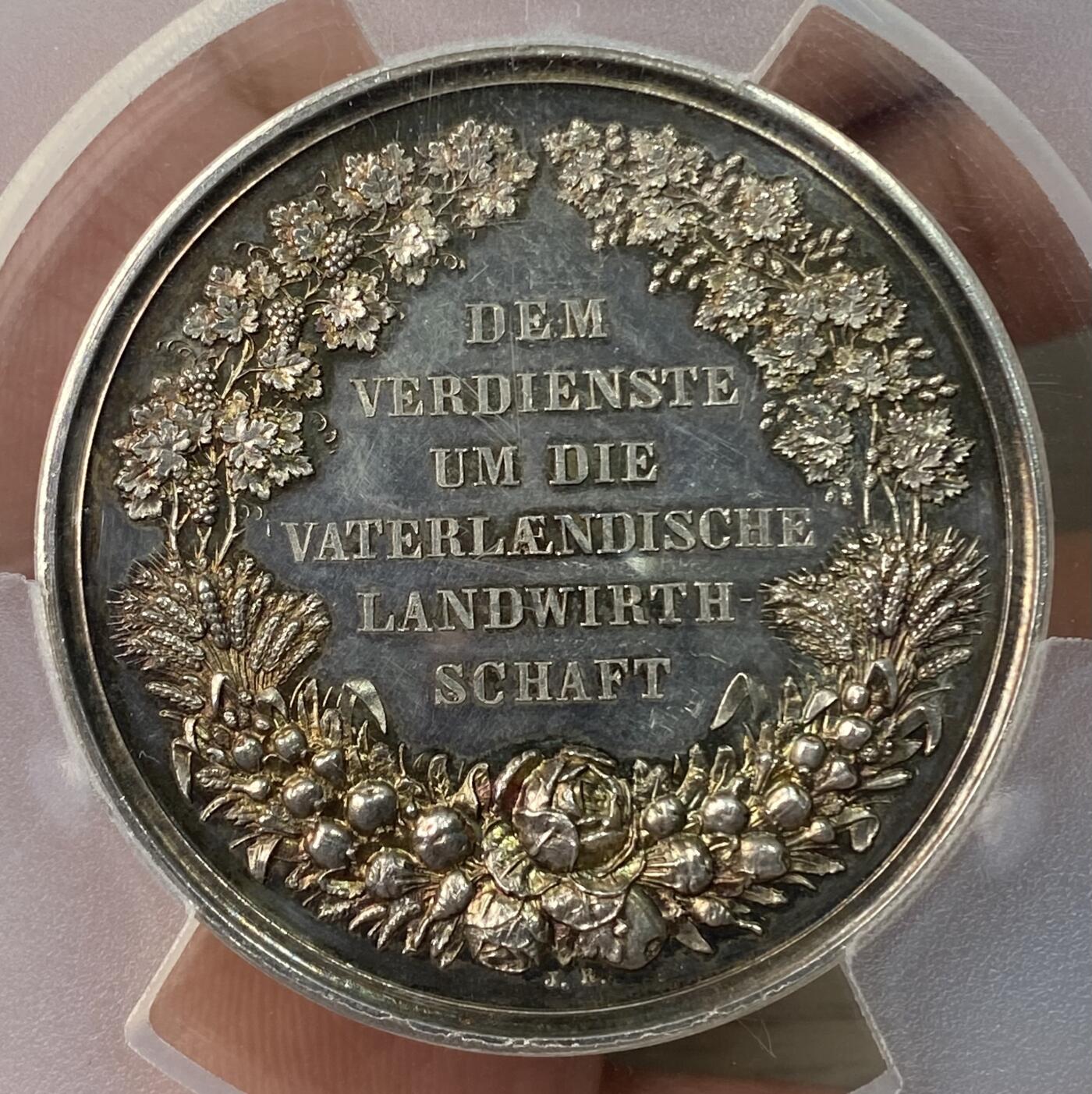 万国钱币拍卖第064期 PCGS SP63 1864-86年间德国巴伐利亚路德维希二世时期农业奖励大银章 小型易得 大规格首见 极美全镜面精铸七彩色调环绕 背面寓意丰收的高浮雕植物藤蔓精致美丽