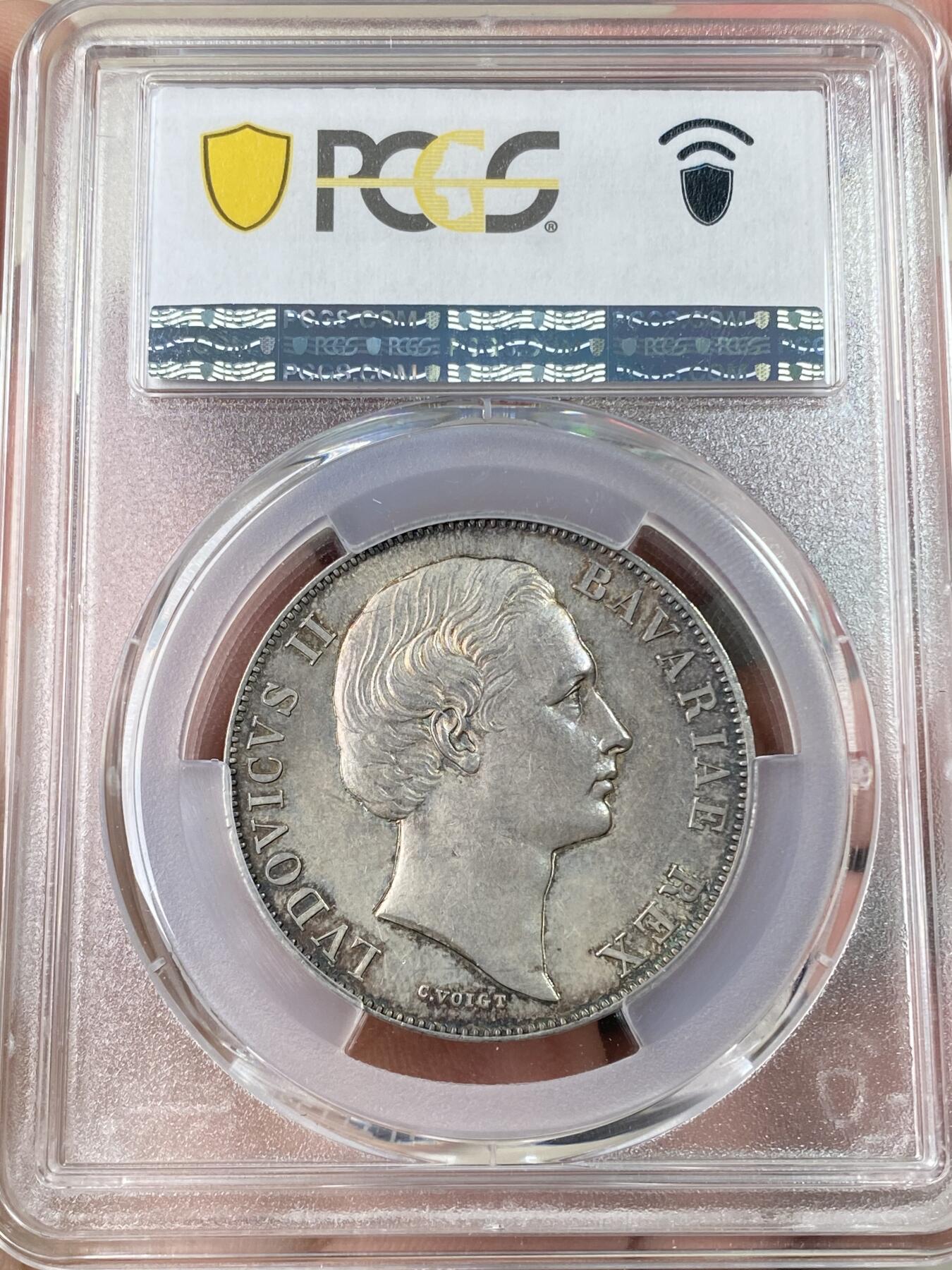 万国钱币拍卖第064期 PCGS MS63 1865年德国巴伐利亚路德维希二世圣母抱婴流通1泰勒 无纪年版本相对稀少 原味欧洲孔雀蓝色调浓郁老彩包浆环绕收藏级品质