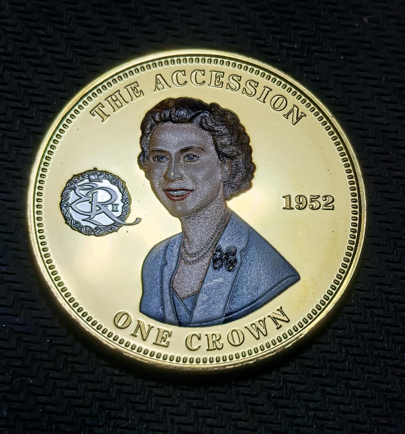 外国优质银币克朗币纪念章，每周六晚九点倒数截拍，满百包邮可寄存，持续收拍 镀金特里斯坦-达库尼亚群岛2014 年伊丽莎白二世 登基 1 克朗纪念币。正面呈现女王晚年肖像，背面还原其年轻时的登基形象及花押字，追溯女王开启 70 年统治的历史起点。