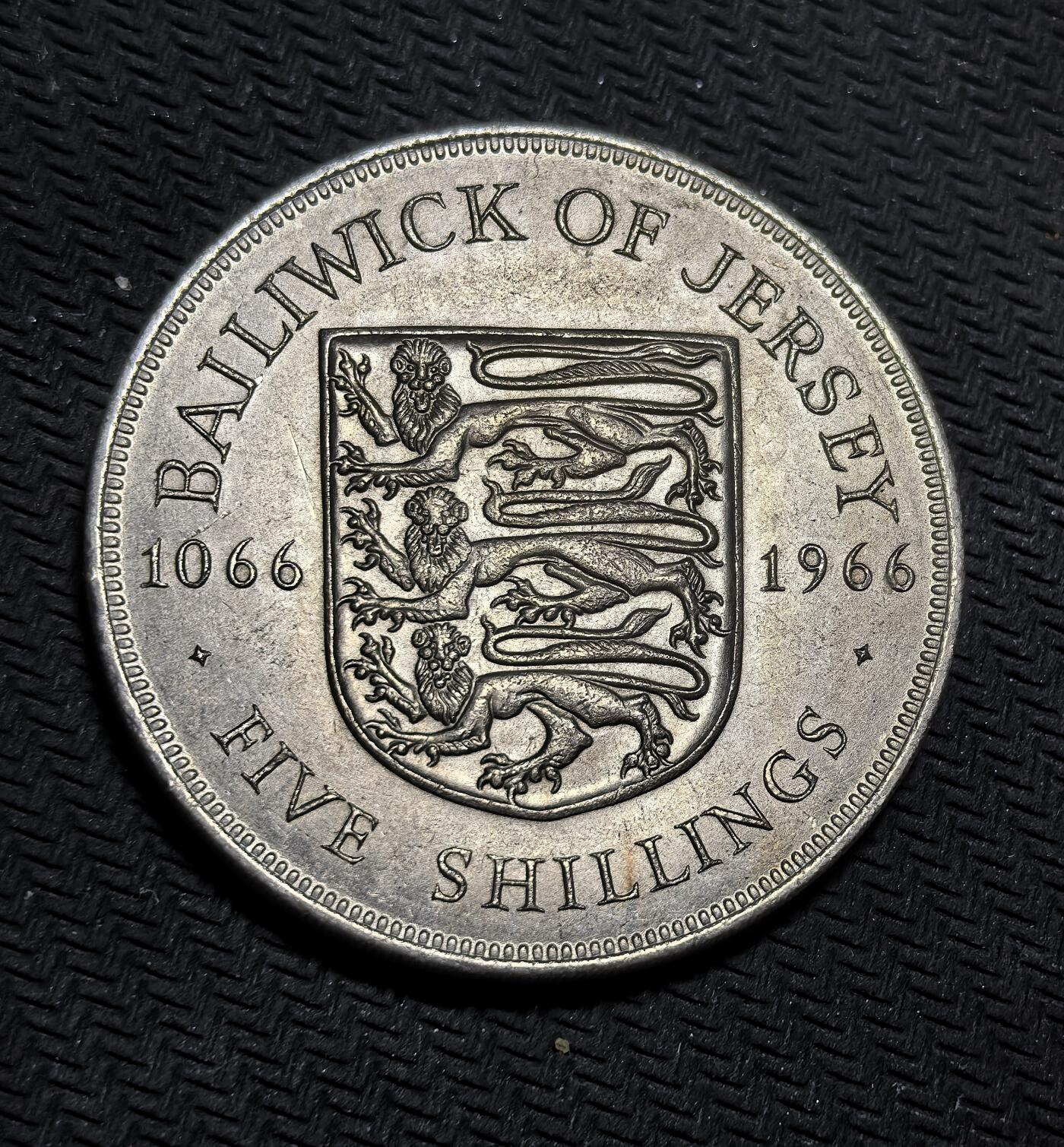 外国优质银币克朗币纪念章，每周六晚九点倒数截拍，满百包邮可寄存，持续收拍 泽西岛1966年5先令纪念币，为纪念诺曼底公爵征服英格兰 900 周年发行。正面为伊丽莎白二世肖像，背面展示泽西岛纹章与三头狮子，定格海岛历史与英王室传承。