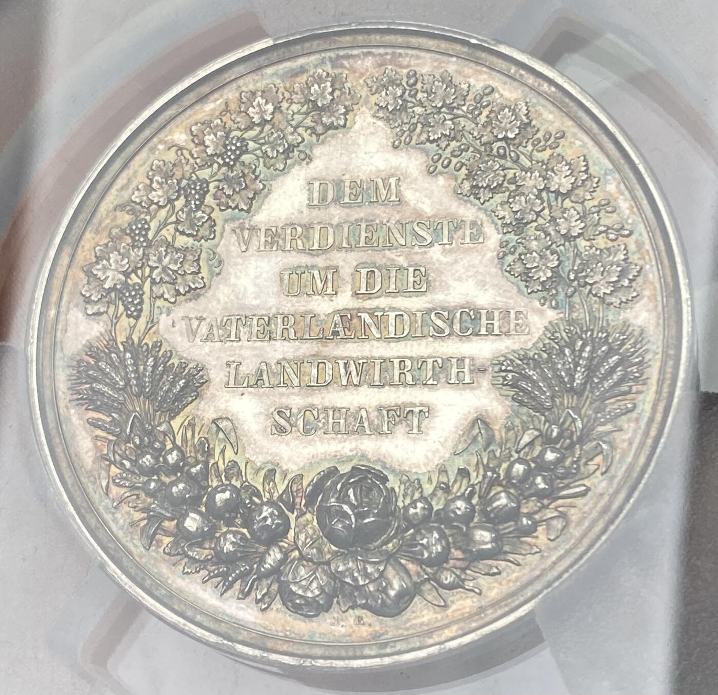 万国钱币拍卖第064期 PCGS SP63 1864-86年间德国巴伐利亚路德维希二世时期农业奖励大银章 小型易得 大规格首见 极美全镜面精铸七彩色调环绕 背面寓意丰收的高浮雕植物藤蔓精致美丽