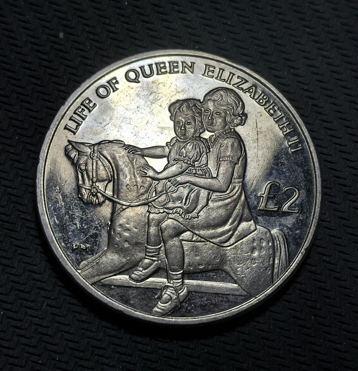 外国优质银币克朗币纪念章，每周六晚九点倒数截拍，满百包邮可寄存，持续收拍 英属印度洋领地2012年2镑纪念币，为纪念伊丽莎白二世登基钻禧发行，正面是女王不同时期双肖像，背面定格其幼年骑马场景，致敬女王一生与君主生涯。