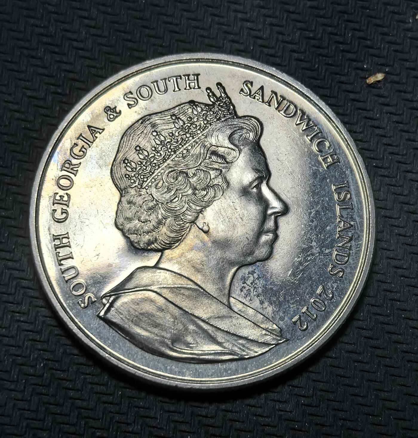 外国优质银币克朗币纪念章，每周六晚九点倒数截拍，满百包邮可寄存，持续收拍 南乔治亚与南桑威奇群岛2012年2镑币，为纪念伊丽莎白二世登基钻禧（即位 60 周年）发行，正面是女王肖像，背面以钻石光芒设计致敬女王漫长君主生涯。