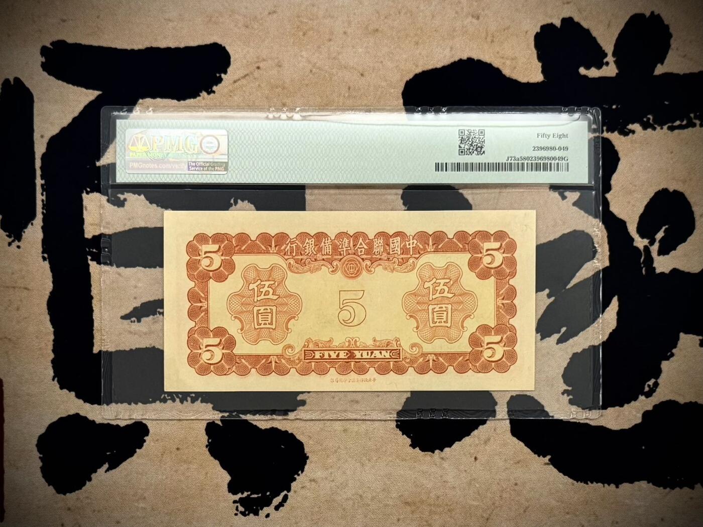 【乾奕收藏】出民国30年1941年中国联合准备银行伍圆，左太和殿右岳飞图案，号码全程无12347金马王靓号，美国PMG58分，油墨浓郁，图案清晰，同分数中状态较为出色的一枚，民国纸币经过80年能保存如此品相实属难得，喜欢的老板不要错过，评级币一切以分数为准，售出非假不退