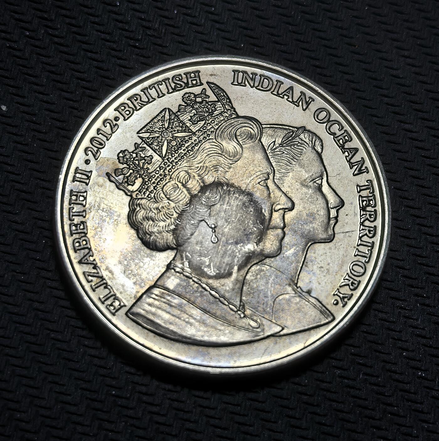 外国优质银币克朗币纪念章，每周六晚九点倒数截拍，满百包邮可寄存，持续收拍 英属印度洋领地2012年2镑纪念币，为纪念伊丽莎白二世登基钻禧发行，正面是女王不同时期双肖像，背面定格其经典公众形象，致敬女王漫长君主生涯。