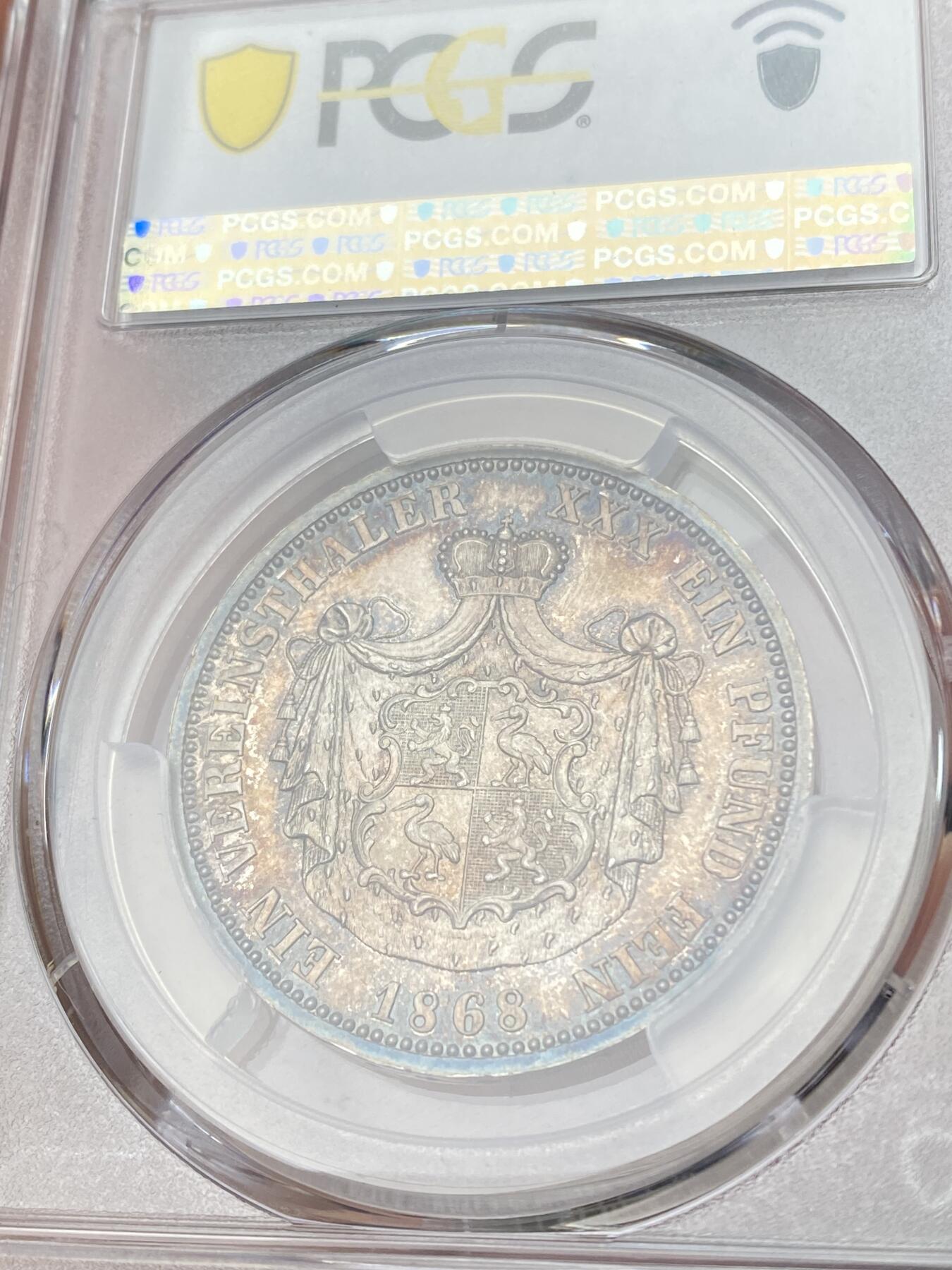 万国钱币拍卖第064期 PCGS PR63 1868年德国罗伊斯-上格莱茨精制纹章1泰勒 小邦中也是名列前茅的高难品种 仅单年发行7100枚 普制好品已是难得一见 精制更是凤毛麟角 精制镜面地板在靛蓝环五彩的加持下给人以强烈的视觉冲击 错过难再寻的顶级收藏品质