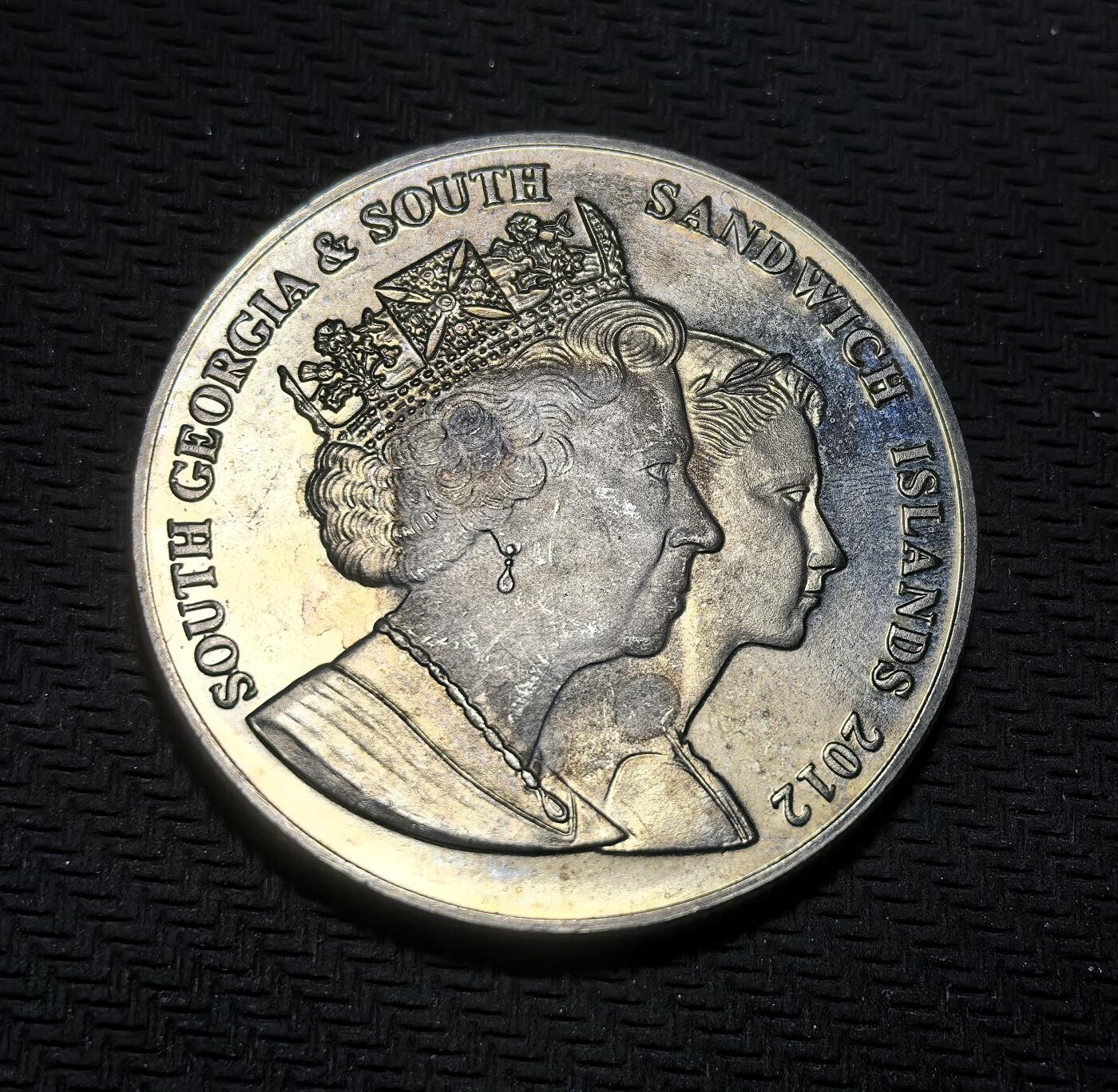 外国优质银币克朗币纪念章，每周六晚九点倒数截拍，满百包邮可寄存，持续收拍 南乔治亚与南桑威奇群岛2012年2镑纪念币，为纪念伊丽莎白二世登基钻禧发行，正面是女王不同时期双肖像，背面刻画女王幼年与母亲，定格其人生起点，致敬女王一生。