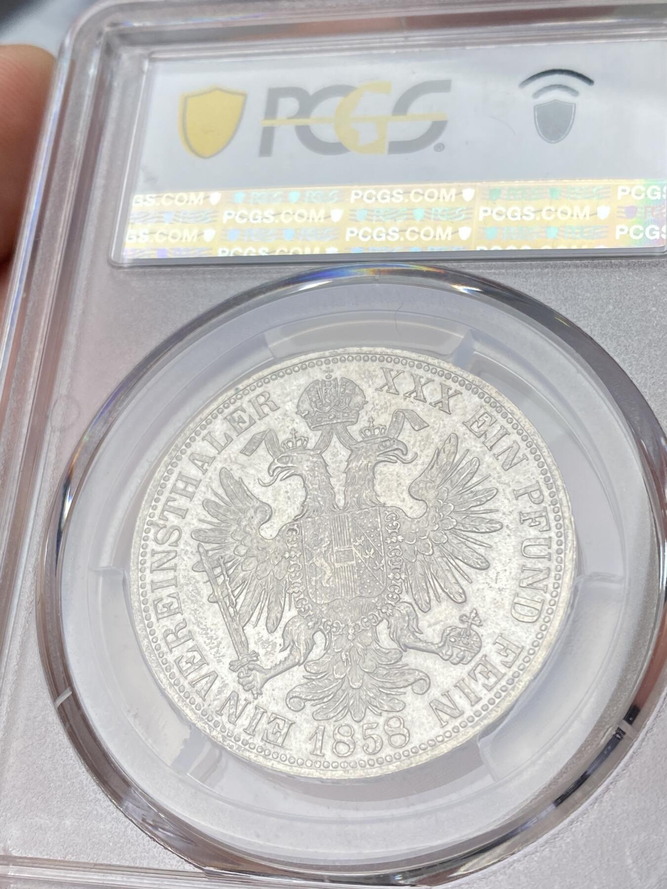 万国钱币拍卖第064期 PCGS MS63 1858年奥地利弗朗茨一世双头鹰流通1泰勒 维也纳货币协议的产物 与德国联合泰勒形制相同 车轮转光欧陆原味淡彩环绕极美收藏品质