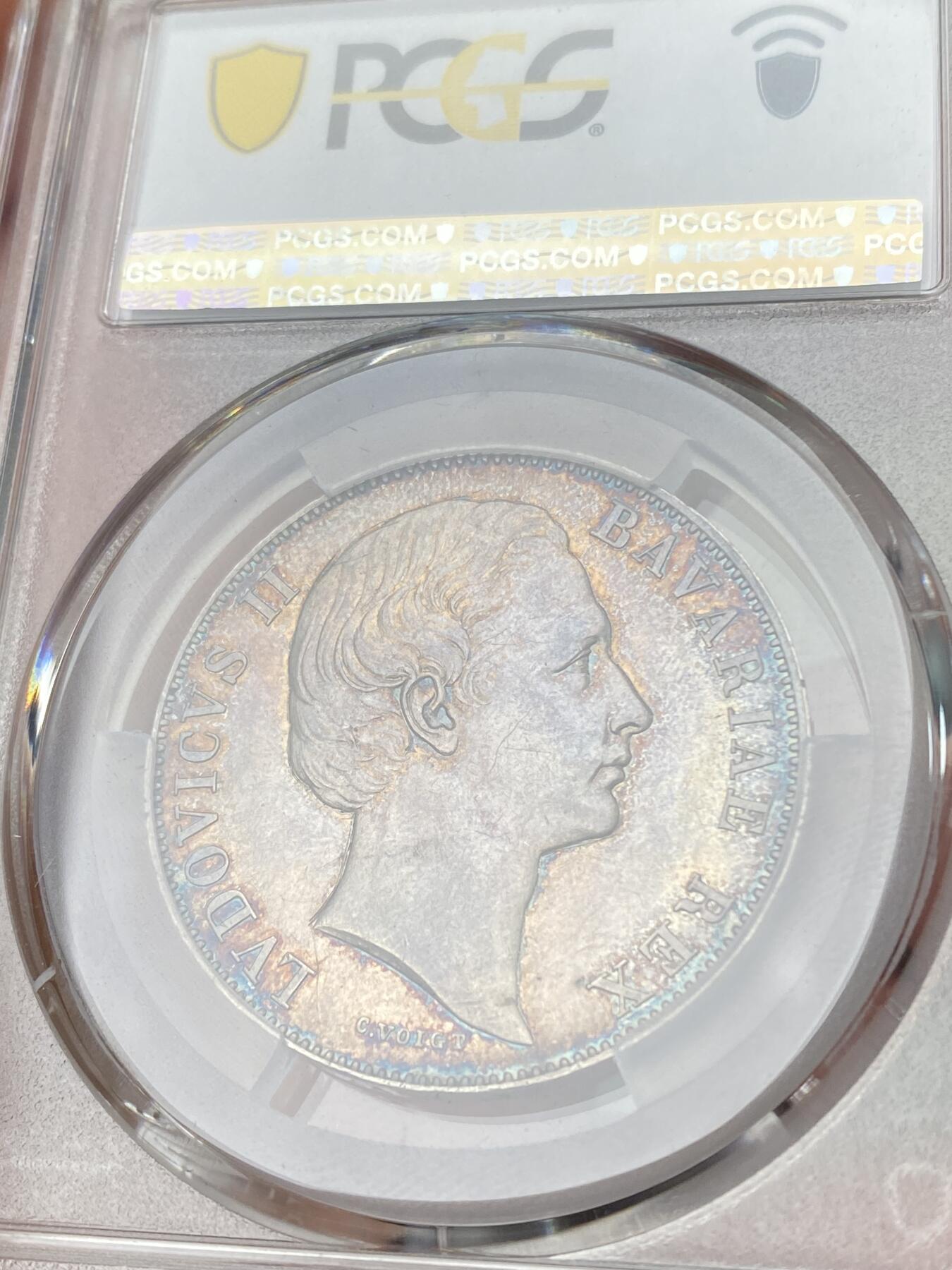 万国钱币拍卖第064期 PCGS MS63 1865年德国巴伐利亚路德维希二世圣母抱婴流通1泰勒 无纪年版本相对稀少 原味欧洲孔雀蓝色调浓郁老彩包浆环绕收藏级品质