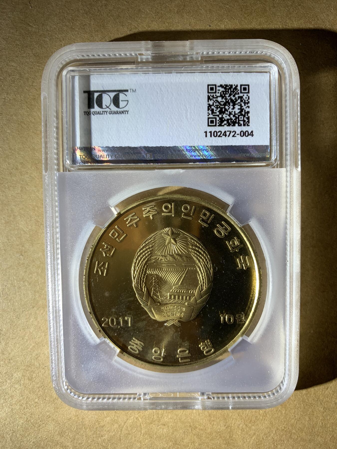 【礼羽收藏】🌏世界钱币拍卖第132期 朝鲜2017年发行的10元纪念币，纪念最高人民会议成立100周年，评级PF 67 UC（精制币，镜面深打67分）。材质是铜镍合金，金黄色调，正面有“志远”和松树图案。