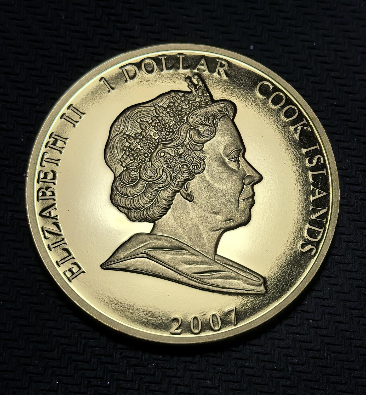 外国优质银币克朗币纪念章，每周六晚九点倒数截拍，满百包邮可寄存，持续收拍 镀金库克群岛2007年1元纪念币，为纪念伊丽莎白二世与菲利普亲王钻石婚发行，正面是女王标准肖像，背面为夫妇合影，定格王室婚姻传奇。