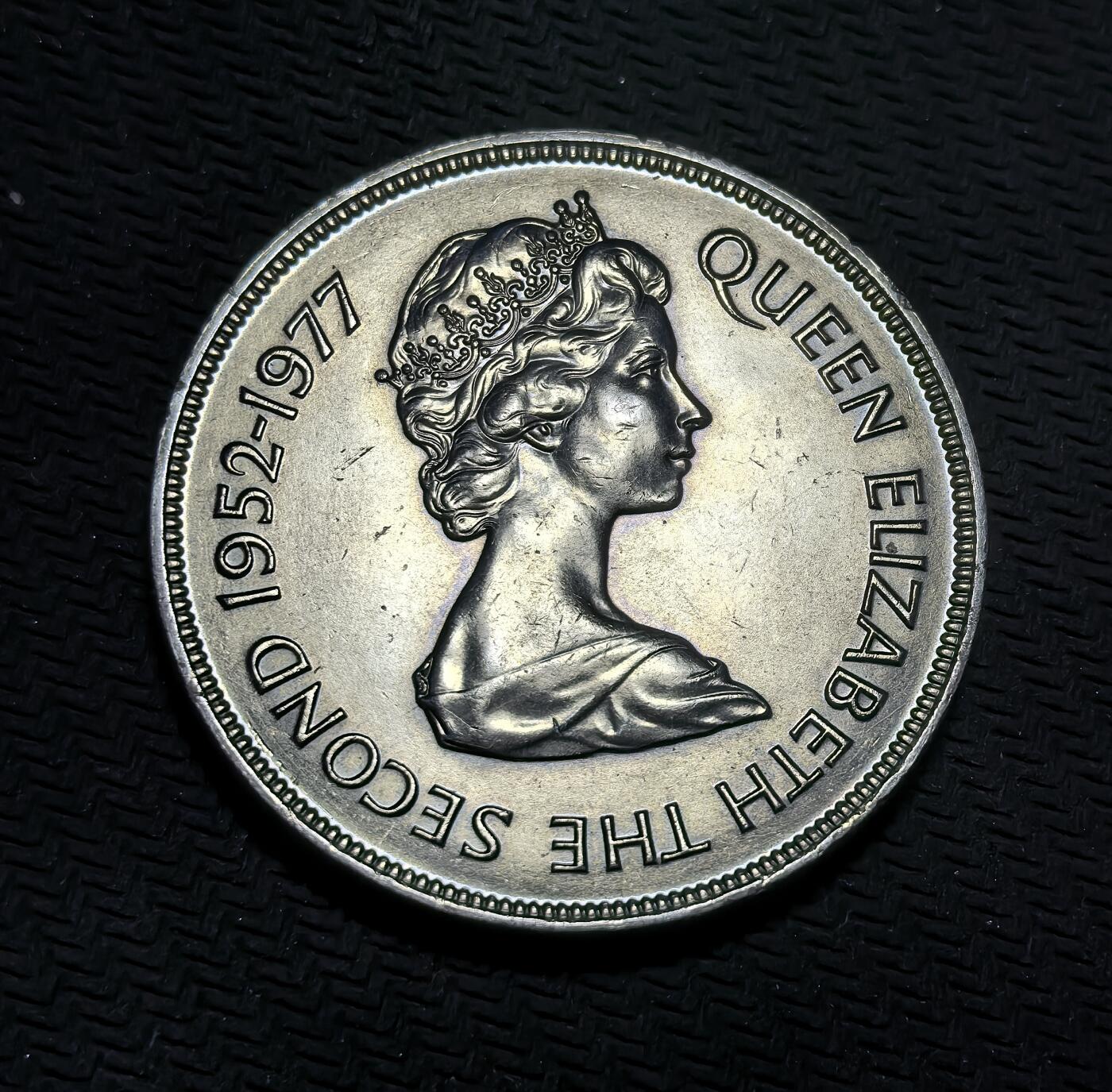 外国优质银币克朗币纪念章，每周六晚九点倒数截拍，满百包邮可寄存，持续收拍 根西岛1977年伊丽莎白二世登基银禧 25 便士纪念币，正面是女王肖像，背面为根西岛城堡地标，见证英王室与海峡群岛的联结。