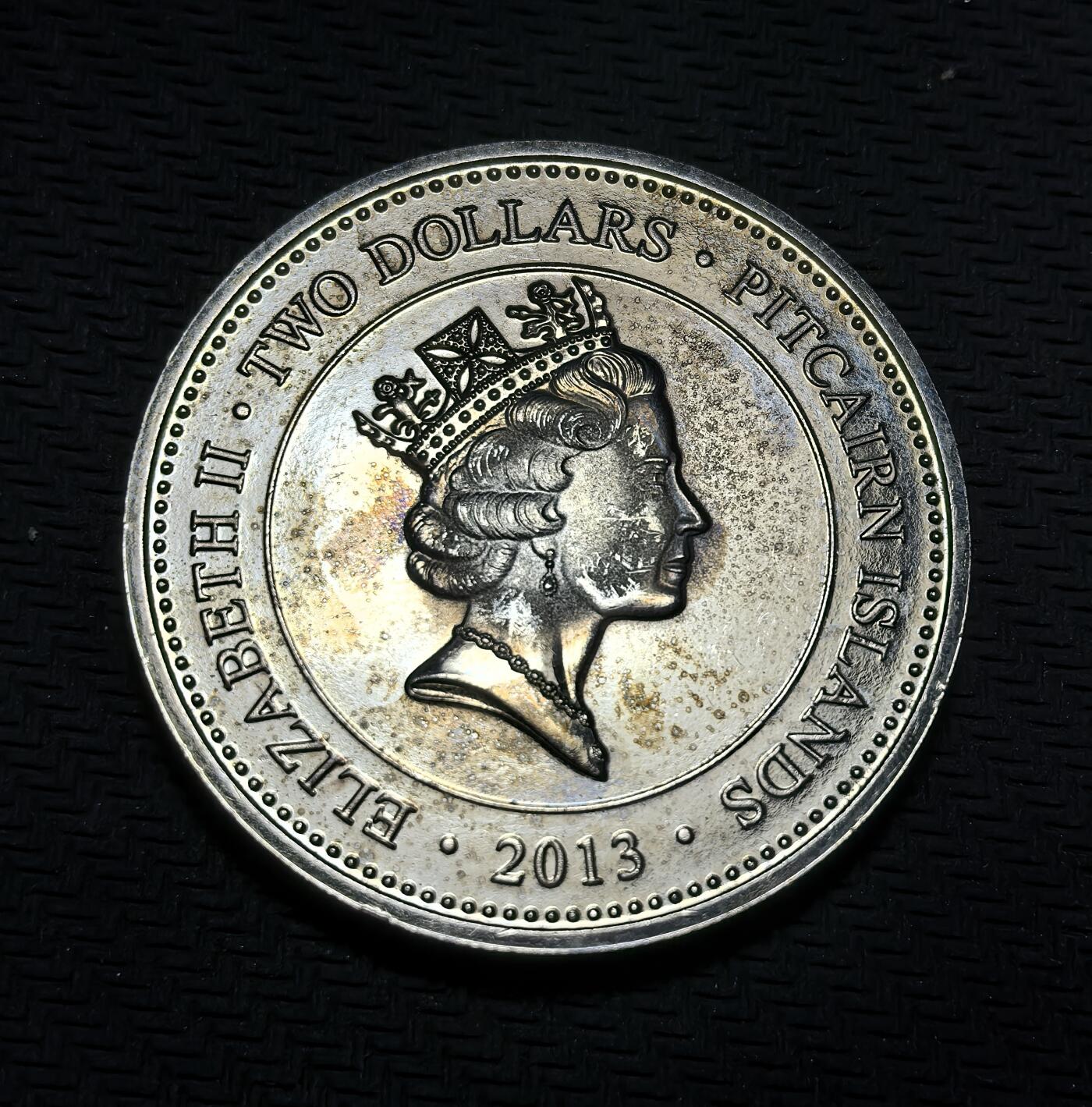 外国优质银币克朗币纪念章，每周六晚九点倒数截拍，满百包邮可寄存，持续收拍 皮特凯恩群岛2013年2元纪念币，为纪念伊丽莎白二世加冕 60 周年发行，正面是女王标准肖像，背面以圣爱德华王冠与英联邦各国象征花卉，致敬加冕盛典与英联邦联结。