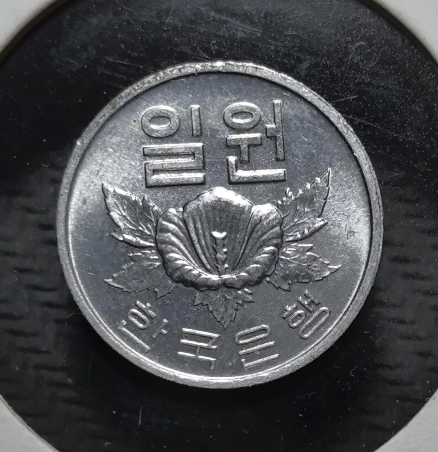 外国优质银币克朗币纪念章，每周六晚九点倒数截拍，满百包邮可寄存，持续收拍 带光韩国 1976 年 1 韩元流通币，正面为韩国国花木槿花，背面标注韩国银行，是韩国战后经济腾飞期的法定辅币，见证了韩国现代货币体系的发展。