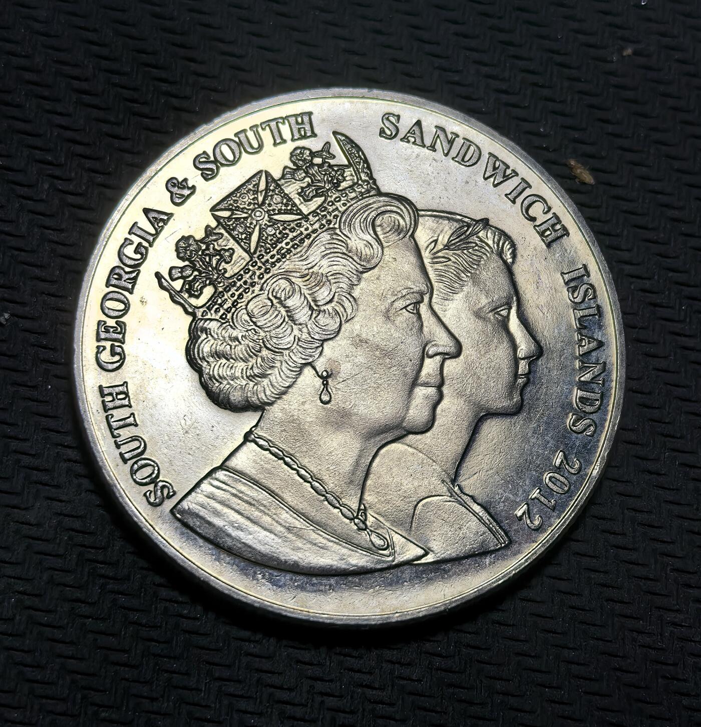 外国优质银币克朗币纪念章，每周六晚九点倒数截拍，满百包邮可寄存，持续收拍 南乔治亚与南桑威奇群岛2012年2镑纪念币，为纪念伊丽莎白二世登基钻禧发行，正面是女王不同时期双肖像，背面定格其经典造型，致敬女王一生与君主生涯。