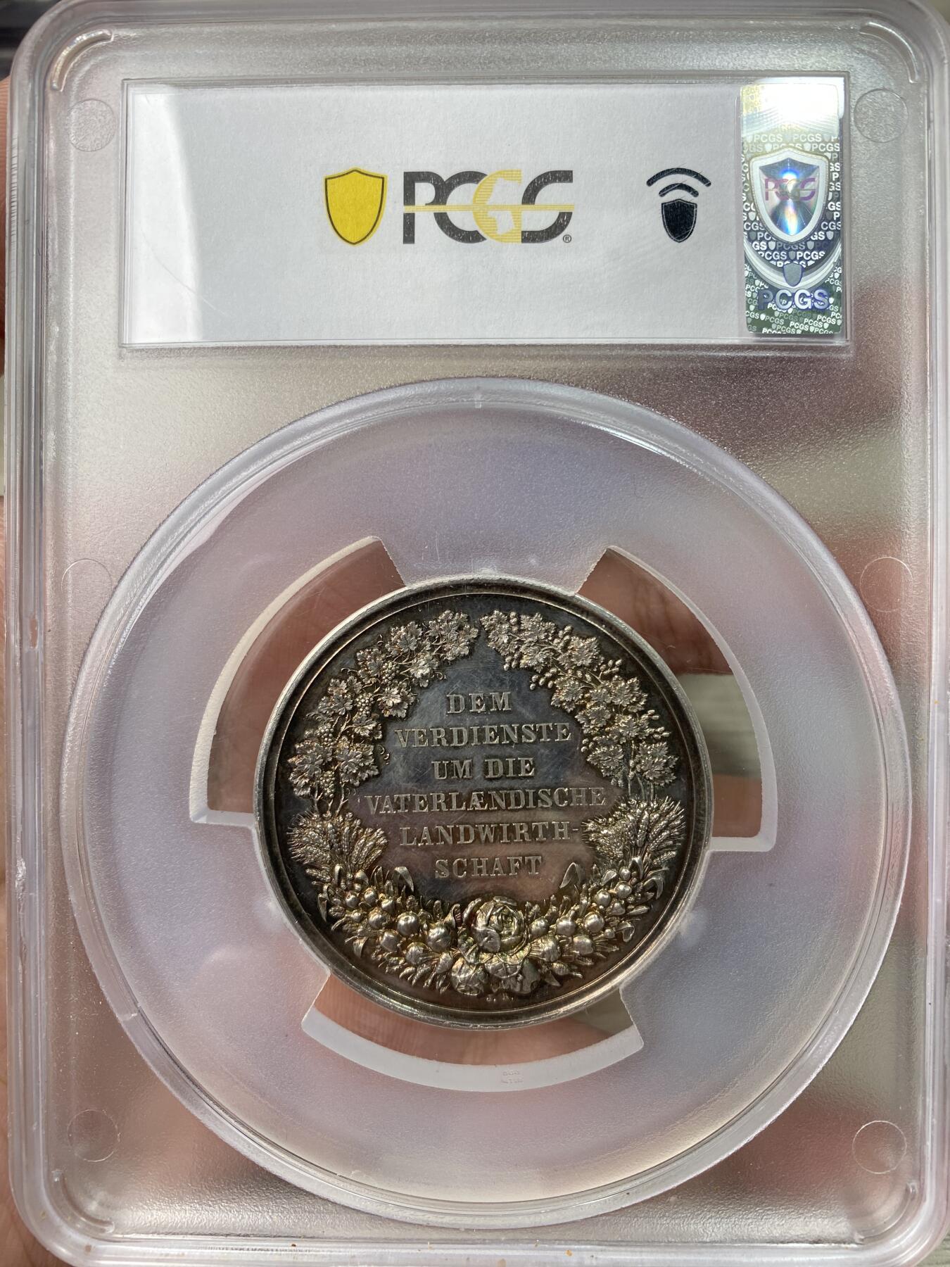 万国钱币拍卖第064期 PCGS SP63 1864-86年间德国巴伐利亚路德维希二世时期农业奖励大银章 小型易得 大规格首见 极美全镜面精铸七彩色调环绕 背面寓意丰收的高浮雕植物藤蔓精致美丽