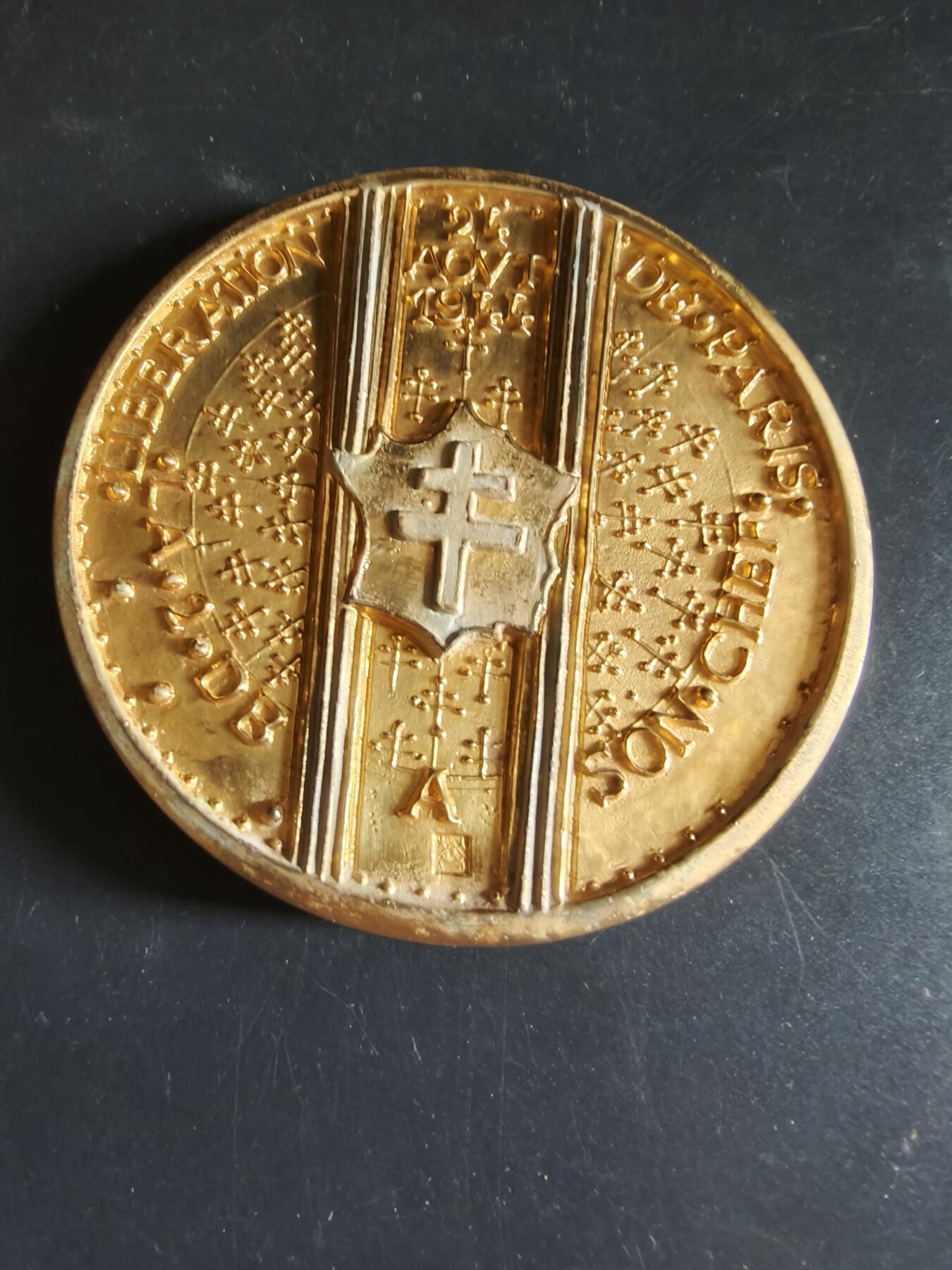 老王徽章第191期 法国勒克莱尔将军1944年解放巴黎镀金大铜章     原盒带证书     带边铭      青铜镀24k金      大师阿尔贝·德·耶格尔作品       勒克莱尔是二战自由法国的传奇将领，戴高乐最信任的将领之一，1944年率领法国第2装甲师率先攻入巴黎，迫使德军投降，终结了巴黎4年的纳粹占领，被尊为“巴黎解放者”        直径11cm       重量677.8g