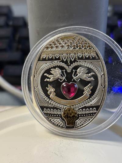第196期拍卖 - 纽埃2011年皇家爱情彩蛋天使之箭镶红水晶椭圆银币，925银，28.28克，币有瑕疵，塑料盒有裂痕