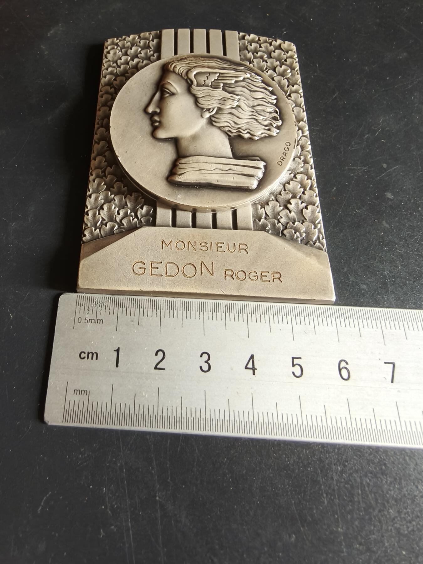 老王徽章第191期 法国1969年乌当世圣马蒂厄集市900周年方形镀银大铜章     原盒     正面为胜利女神形象    乌当市是法国中世纪重要的商贸城镇，圣马蒂厄集市最初是农业、牲畜交易集市，如今已发展为融合民俗、娱乐、商业的综合性节庆       尺寸80×60mm      重量266.6g