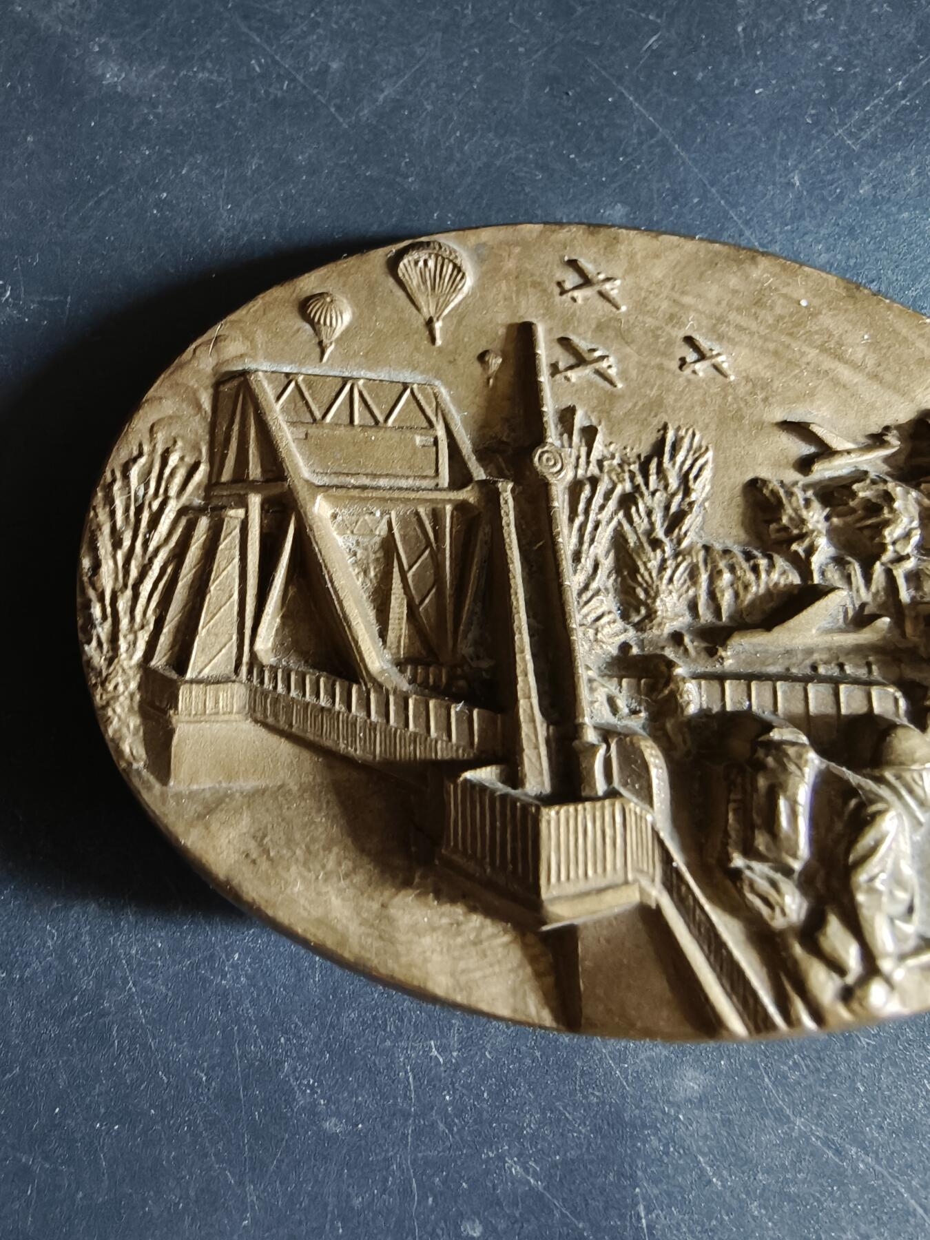 老王徽章第191期 法国诺曼底登陆纪念委员会异形大铜章     高浮雕     正面描绘了英国王牌第6空降师夺取飞马桥，阻止德军装甲部队向滩头阵地增援的场景          尺寸80×58mm      重量322.3g  