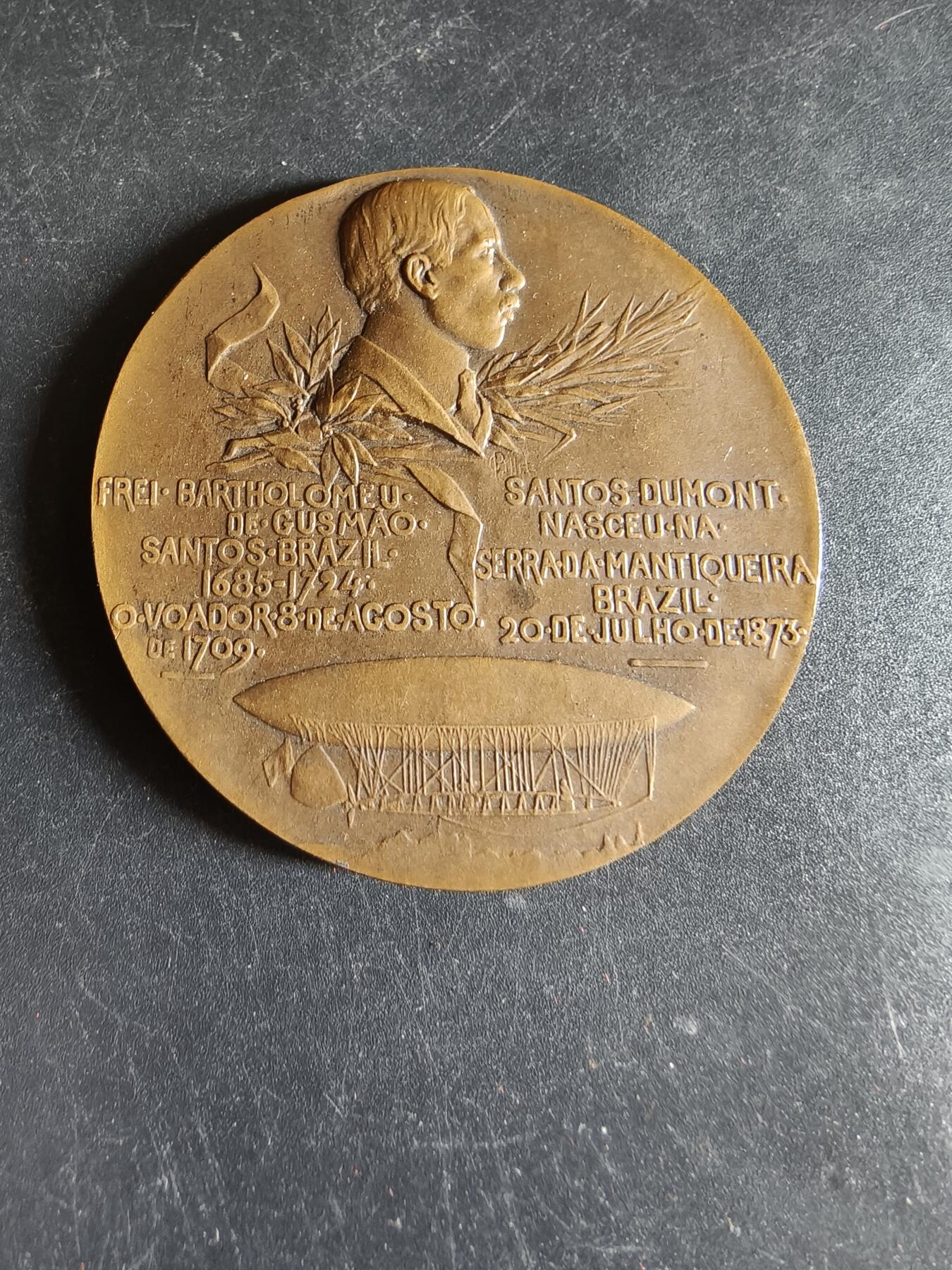 老王徽章第191期 法国驻巴黎巴西侨民直径阿尔贝托·桑托斯-杜蒙大铜章     原盒      新艺术风格航空女神形象    阿尔贝托·桑托斯·杜蒙为巴西传奇航空先驱、人类航空史的奠基人之一，被巴西尊为“航空之父”，发明了飞艇并成功于1906年驾驶6号飞艇完成环绕埃菲尔铁塔飞行一圈并返航         大师皮列作品       直径50mm    重量56g 