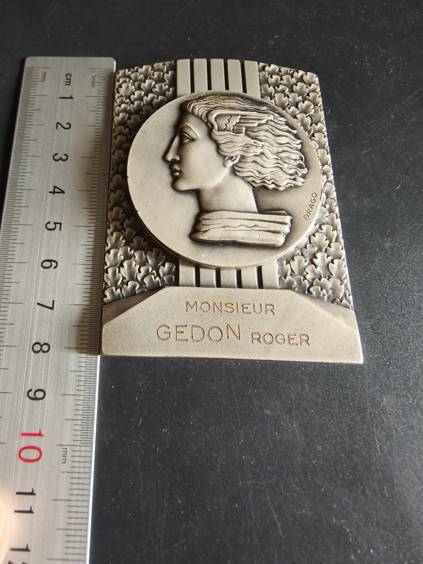 老王徽章第191期 法国1969年乌当世圣马蒂厄集市900周年方形镀银大铜章     原盒     正面为胜利女神形象    乌当市是法国中世纪重要的商贸城镇，圣马蒂厄集市最初是农业、牲畜交易集市，如今已发展为融合民俗、娱乐、商业的综合性节庆       尺寸80×60mm      重量266.6g