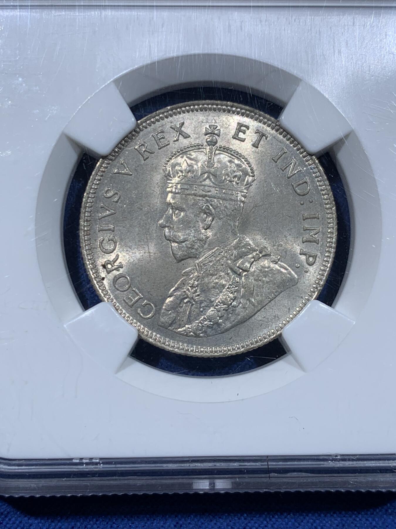 《竞宝斋》第477场 周日，周一 2场连拍 （全场包邮）欢迎送拍 NGC MS63 东非1925年乔治五世1先令银币，原光，最大面值主币。肌肉虬结的雄狮漫步于乞力马扎罗山下，图案设计极富特色。老N盒保障，银光丝滑。此前竞宝斋同分1008元不含佣成交