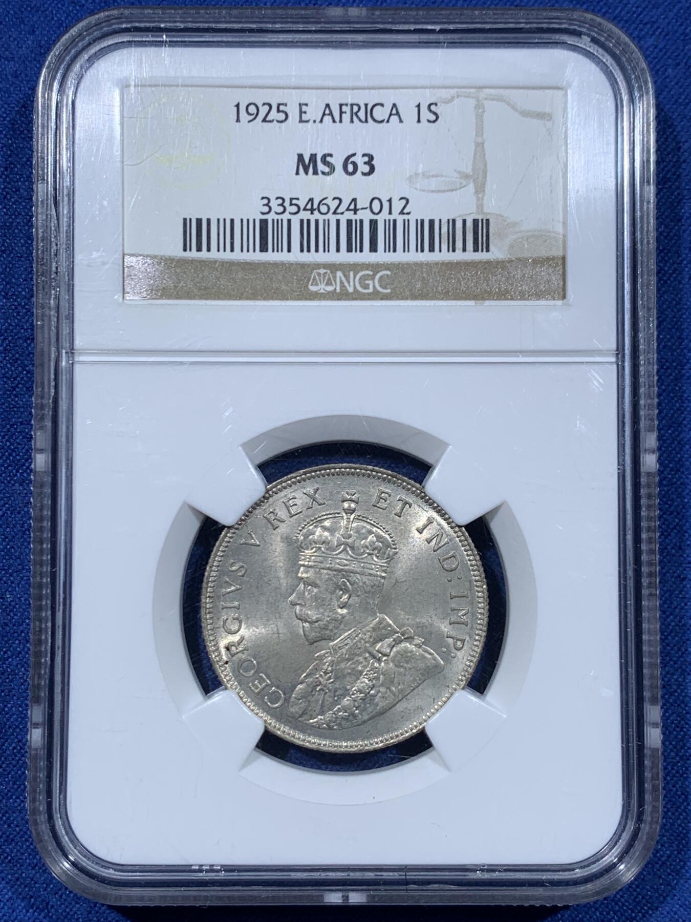 《竞宝斋》第477场 周日，周一 2场连拍 （全场包邮）欢迎送拍 NGC MS63 东非1925年乔治五世1先令银币，原光，最大面值主币。肌肉虬结的雄狮漫步于乞力马扎罗山下，图案设计极富特色。老N盒保障，银光丝滑。此前竞宝斋同分1008元不含佣成交