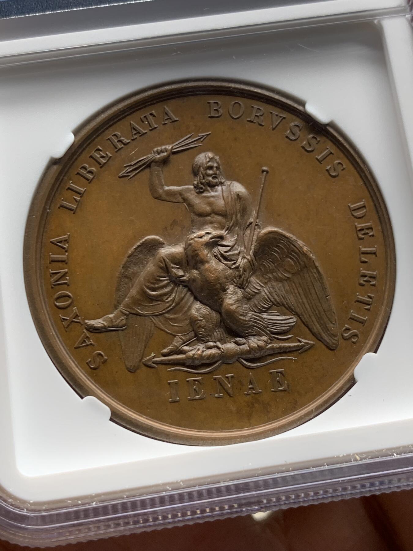 《竞宝斋》第477场 周日，周一 2场连拍 （全场包邮）欢迎送拍 NGC MS63BN 法国拿破仑一世铜章 纪念1806年耶拿战役 正面为桂冠版拿破仑一世右向肖像，背面为骑乘雄鹰的神祇宙斯形象，手持雷霆与权杖，象征胜利与权力，主题指向法军在耶拿击败普鲁士军队的战役结果。加厚盒