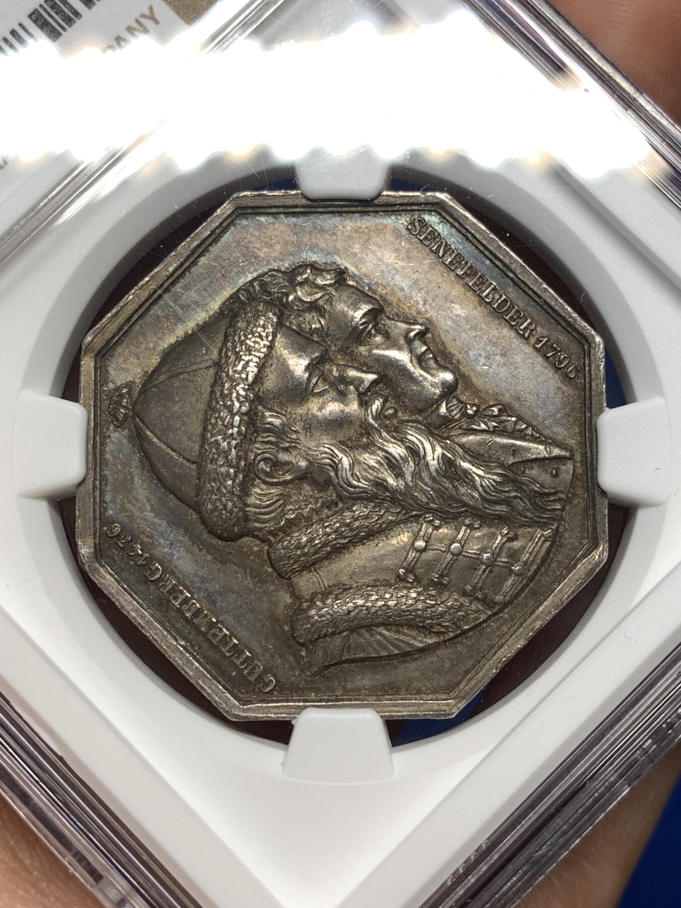 《竞宝斋》第477场 周日，周一 2场连拍 （全场包邮）欢迎送拍 NGC MS62 法国1836年巴黎印刷商发行的古腾堡与塞纳菲尔德纪念八角银质代币，19世纪欧洲印刷术题材稀缺藏品，巴黎印刷博物馆、法国国家图书馆有同款银质馆藏藏品。历史艺术价值高，极具收藏价值。早期蜜蜂边铭难得。直径：35.5mm，重：19.07g，加厚盒。