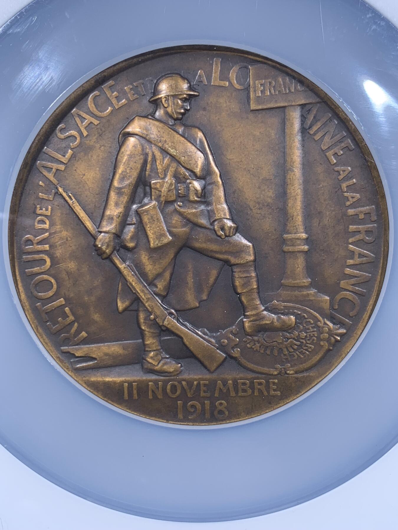 《竞宝斋》第477场 周日，周一 2场连拍 （全场包邮）欢迎送拍 NGC MS63BN 一战主题纪念章，该章纪念法国从德国收复失地法国洛林纪念章，该章由著名雕塑家Paul Roger-Bloche创作（阿尔萨斯-洛林回归）。正面图案，象征法兰西玛丽安娜与阿尔萨斯、洛林地区的女性形象相拥，是“故土回归”的经典艺术代表作。背面图案：法国士兵立于路牌旁，脚下踩着象征德国的鹰徽，象征法国收复失地的历史时刻，该章由巴黎皇家造币厂压铸，现被耶鲁大学艺术画廊等机构收藏，极具背