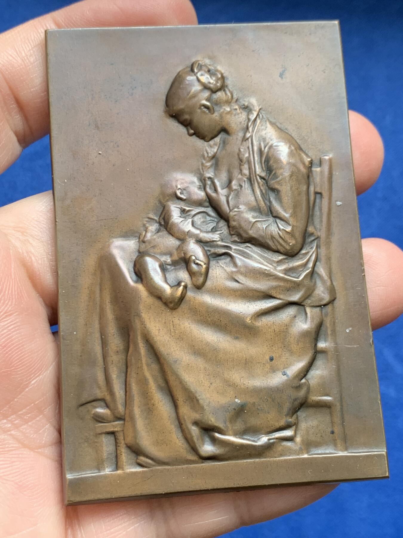 《竞宝斋》第477场 周日，周一 2场连拍 （全场包邮）欢迎送拍 SAMF《母爱》特蕾莎（THERESE 1 MAI 1899）协会作品3号 编号237 本章为法国艺术家亚历山大·沙尔庞捷（Alexandre Charpentier，1856–1909）创作之《母爱》题材铜章，属SAMF（法国艺术家奖章协会）原作发行于1900年。该作品源自艺术家此前创作的“年轻母亲哺乳幼子”浮雕主题，并曾在1883年法国艺术家协会沙龙展出并获奖。143.8克，52.8*80.5