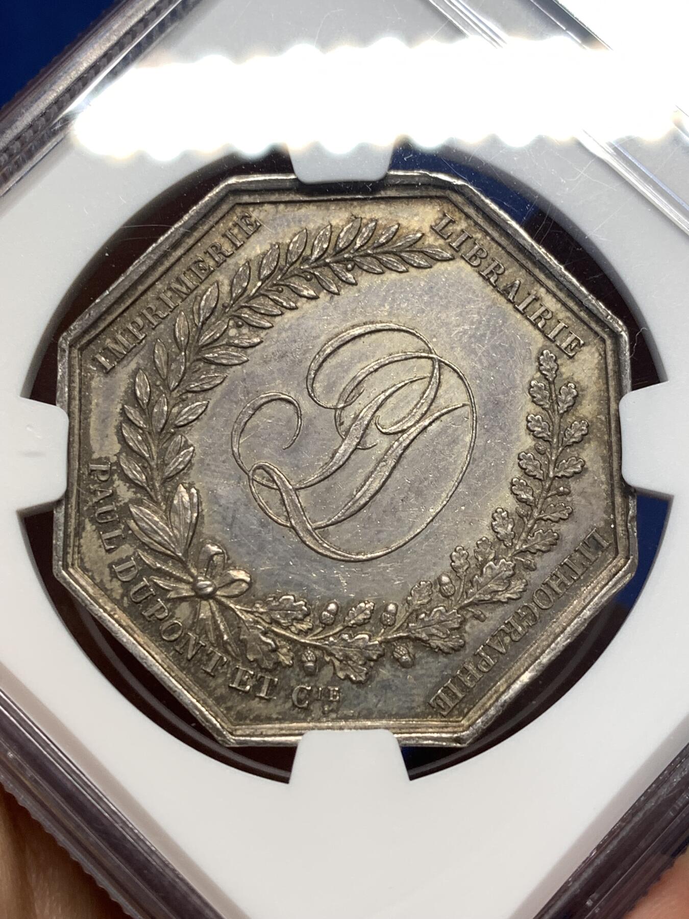 《竞宝斋》第477场 周日，周一 2场连拍 （全场包邮）欢迎送拍 NGC MS62 法国1836年巴黎印刷商发行的古腾堡与塞纳菲尔德纪念八角银质代币，19世纪欧洲印刷术题材稀缺藏品，巴黎印刷博物馆、法国国家图书馆有同款银质馆藏藏品。历史艺术价值高，极具收藏价值。早期蜜蜂边铭难得。直径：35.5mm，重：19.07g，加厚盒。