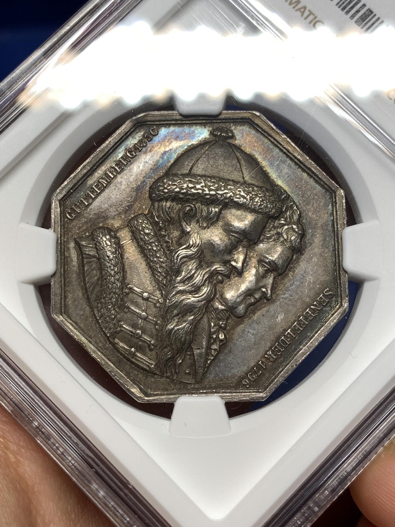 《竞宝斋》第477场 周日，周一 2场连拍 （全场包邮）欢迎送拍 NGC MS62 法国1836年巴黎印刷商发行的古腾堡与塞纳菲尔德纪念八角银质代币，19世纪欧洲印刷术题材稀缺藏品，巴黎印刷博物馆、法国国家图书馆有同款银质馆藏藏品。历史艺术价值高，极具收藏价值。早期蜜蜂边铭难得。直径：35.5mm，重：19.07g，加厚盒。