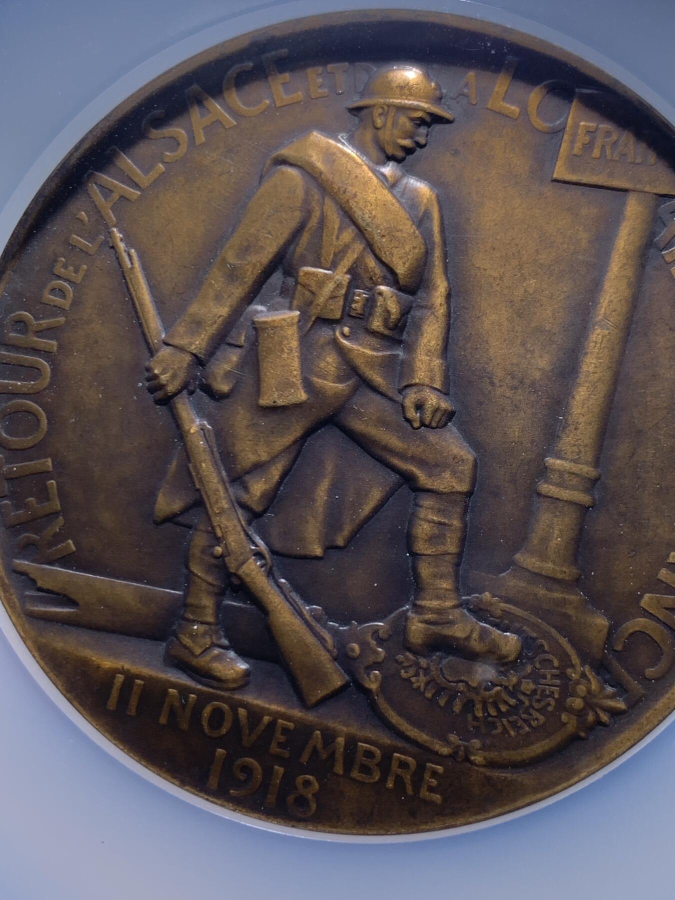 《竞宝斋》第477场 周日，周一 2场连拍 （全场包邮）欢迎送拍 NGC MS63BN 一战主题纪念章，该章纪念法国从德国收复失地法国洛林纪念章，该章由著名雕塑家Paul Roger-Bloche创作（阿尔萨斯-洛林回归）。正面图案，象征法兰西玛丽安娜与阿尔萨斯、洛林地区的女性形象相拥，是“故土回归”的经典艺术代表作。背面图案：法国士兵立于路牌旁，脚下踩着象征德国的鹰徽，象征法国收复失地的历史时刻，该章由巴黎皇家造币厂压铸，现被耶鲁大学艺术画廊等机构收藏，极具背