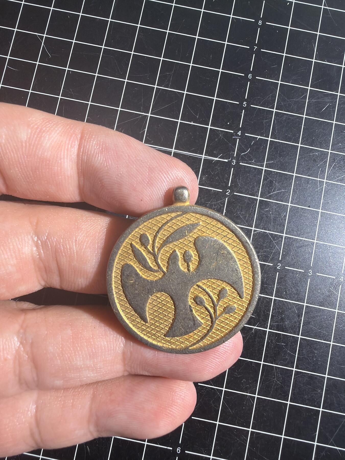 古冰库章牌勋赏收藏0起拍卖 联合国多国部队纪念章，铜质徽章挂件，直径约3.5cm，厚实有分量。正面刻“UNITED IN SERVICE FOR PEACE”，背面“MULTINATIONAL FORCE & OBSERVERS DIRECTOR GENERAL'S AWARD