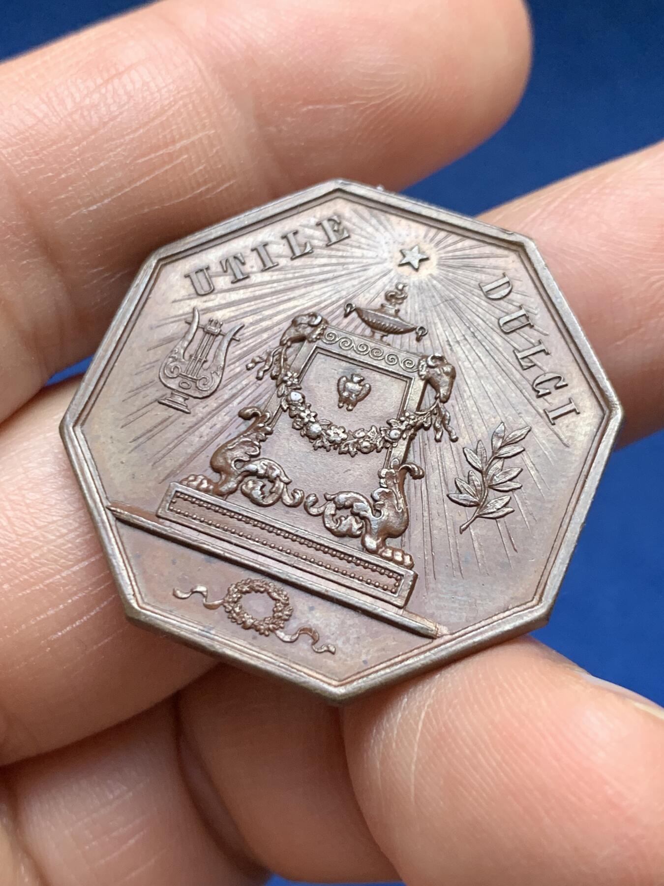 《竞宝斋》第478场 周日，周一 2场连拍 （全场包邮）欢迎送拍 1823年比利时图尔奈文学、科学与美术之友协会八角形纪念章，存世量较少，正面刻有里拉琴（代表文学艺术），月桂枝（象征荣誉），祭坛式纹饰搭配放射状星芒。19世纪新古典艺术主义，具有较高的收藏价值。直径：31.3mm，重：11.55g