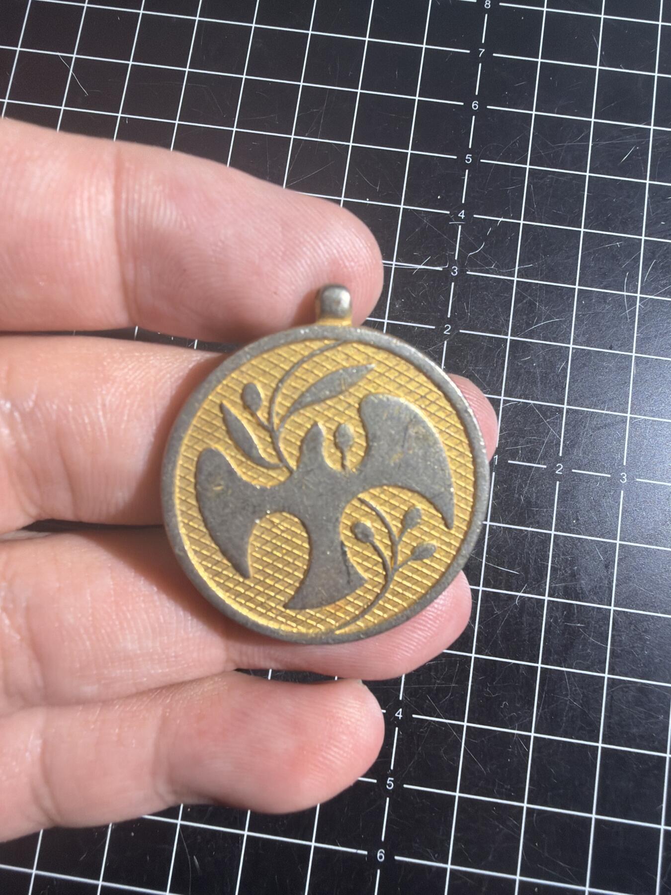 古冰库章牌勋赏收藏0起拍卖 联合国多国部队纪念章，铜质徽章挂件，直径约3.5cm，厚实有分量。正面刻“UNITED IN SERVICE FOR PEACE”，背面“MULTINATIONAL FORCE & OBSERVERS DIRECTOR GENERAL'S AWARD