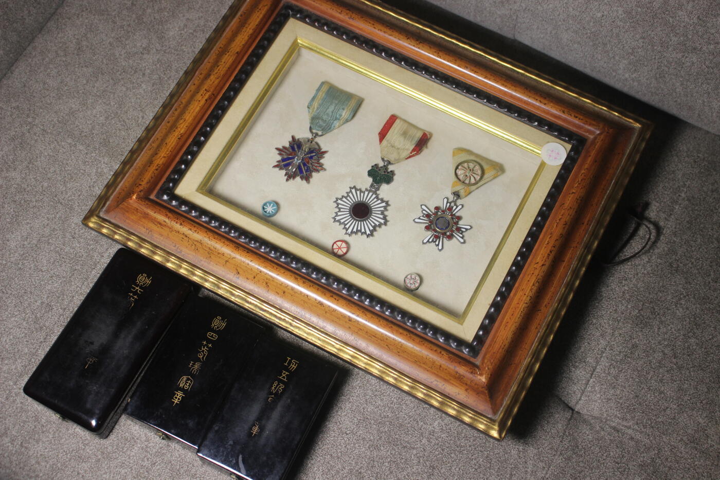 明治五等金鵄、六等旭日、四等瑞宝套装，章体和略章装裱在玻璃木相框中，套装整体非常厚重，章体日常佩戴品相，珐琅轻微缺损，原盒保存完好