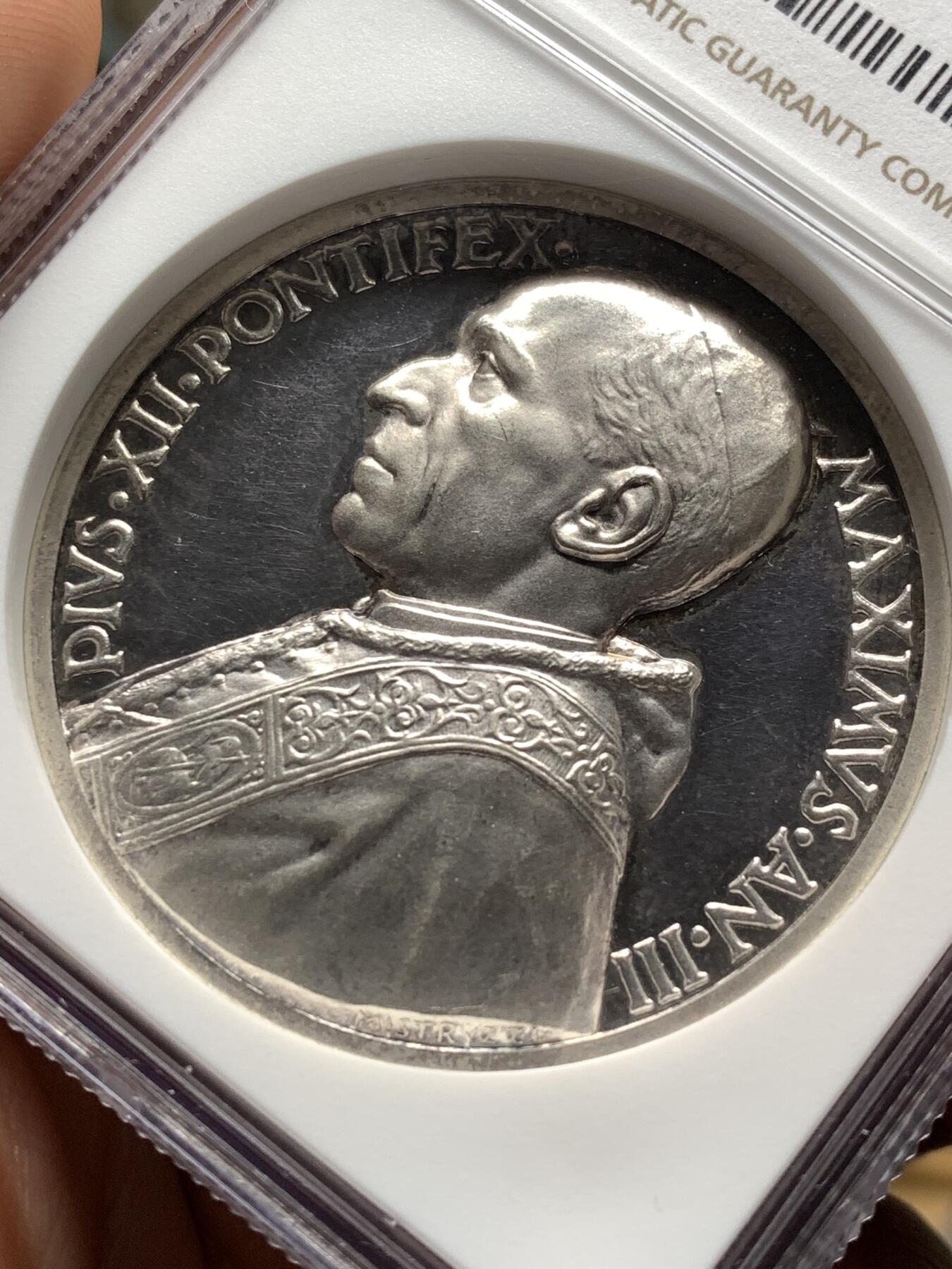 《竞宝斋》第478场 周日，周一 2场连拍 （全场包邮）欢迎送拍 NGC MS64 梵蒂冈1942年庇护十二世大银章，加厚盒。该章是二战时期梵蒂冈重要的和平主义主题银章，是和平呼吁的实物载体，梵蒂冈章牌经典编号Rinaldi-135.由意大利著名章牌雕刻师Alessandro Mistruzzi设计制造。主图案基督向战乱中的民众施以怜悯的场景，铭文“我为民众怜悯”出自《圣经.马可福音》，极具价值及历史意义。加厚盒装