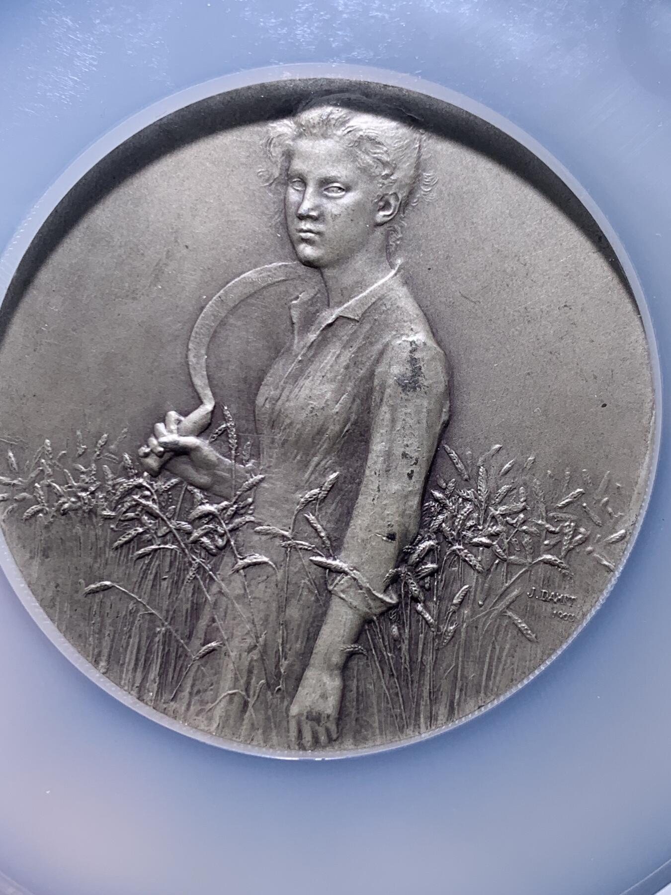 《竞宝斋》第478场 周日，周一 2场连拍 （全场包邮）欢迎送拍 NGC MS64 法国SAMF协会第26号作品《丰收》大银章，名家DAMPT Jean作。重：98.3g。正面年轻女子站立，手持镰刀，立于麦穗丛中。背面耕作场景，前景为荆棘，背景为旭日，天空有雨云。1904年分发，共分发青铜章120枚，银章91枚。边部带有法国奖章之友协会（SAMF）的蜥蜴标记及编号15 加大加厚盒