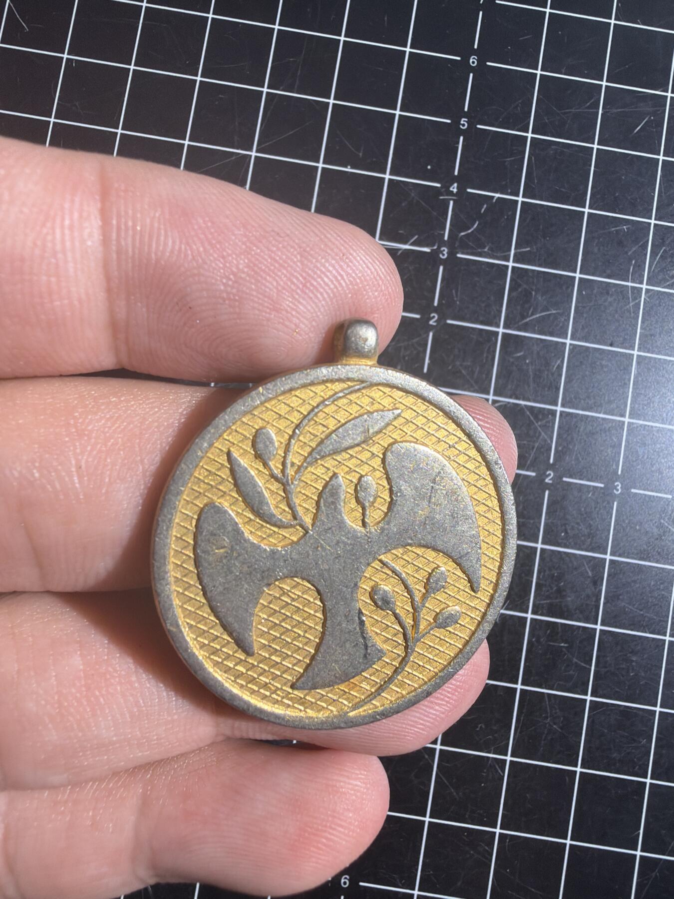 古冰库章牌勋赏收藏0起拍卖 联合国多国部队纪念章，铜质徽章挂件，直径约3.5cm，厚实有分量。正面刻“UNITED IN SERVICE FOR PEACE”，背面“MULTINATIONAL FORCE & OBSERVERS DIRECTOR GENERAL'S AWARD