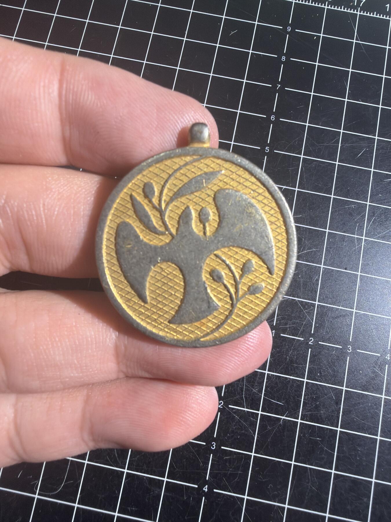 古冰库章牌勋赏收藏0起拍卖 联合国多国部队纪念章，铜质徽章挂件，直径约3.5cm，厚实有分量。正面刻“UNITED IN SERVICE FOR PEACE”，背面“MULTINATIONAL FORCE & OBSERVERS DIRECTOR GENERAL'S AWARD