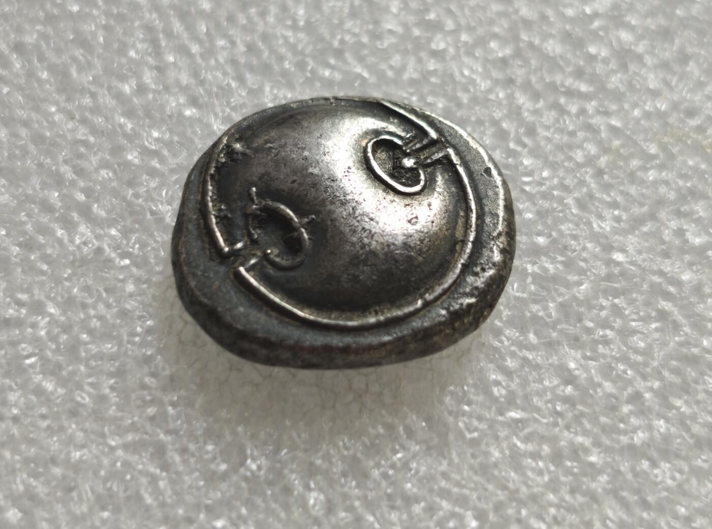 瓶子🏺第236期拍卖会  古希腊波奥提亚同盟底比斯（Thebes，忒拜）城邦发行的银币，属于公元前4世纪（约395-338 BC）的希腊古典时代货币，是古希腊最具代表性的城邦银币之一  波奥提亚盾牌，这是底比斯/波奥提亚同盟的标志性符号，为圆形凸面盾，盾面两侧的弧形缺口是其最显著特征，象征城邦的军事力量与同盟身份  双耳调酒器（坎塔罗斯杯/奖杯），这是古希腊酒神狄俄尼索斯的象征，代表底比斯的酒神崇拜与城邦文化  